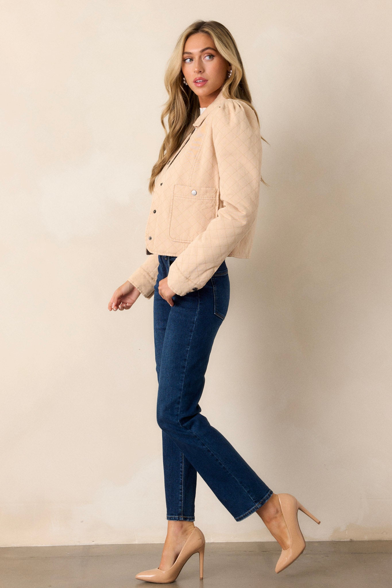 Full length side view of a taupe jacket with a collared neckline, a functional button front, puffed shoulders, and a slightly cropped hemline