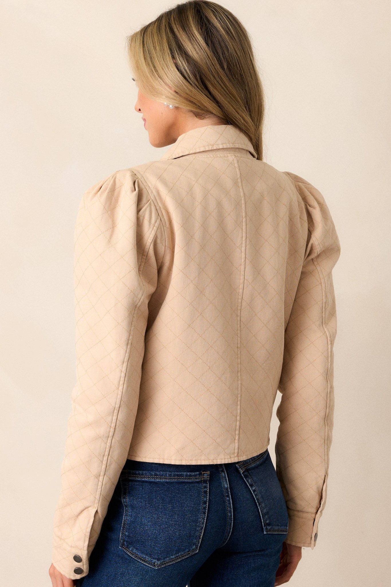 Back view of a taupe jacket highlighting the overall fit, puffed shoulders, and slightly cropped hemline.