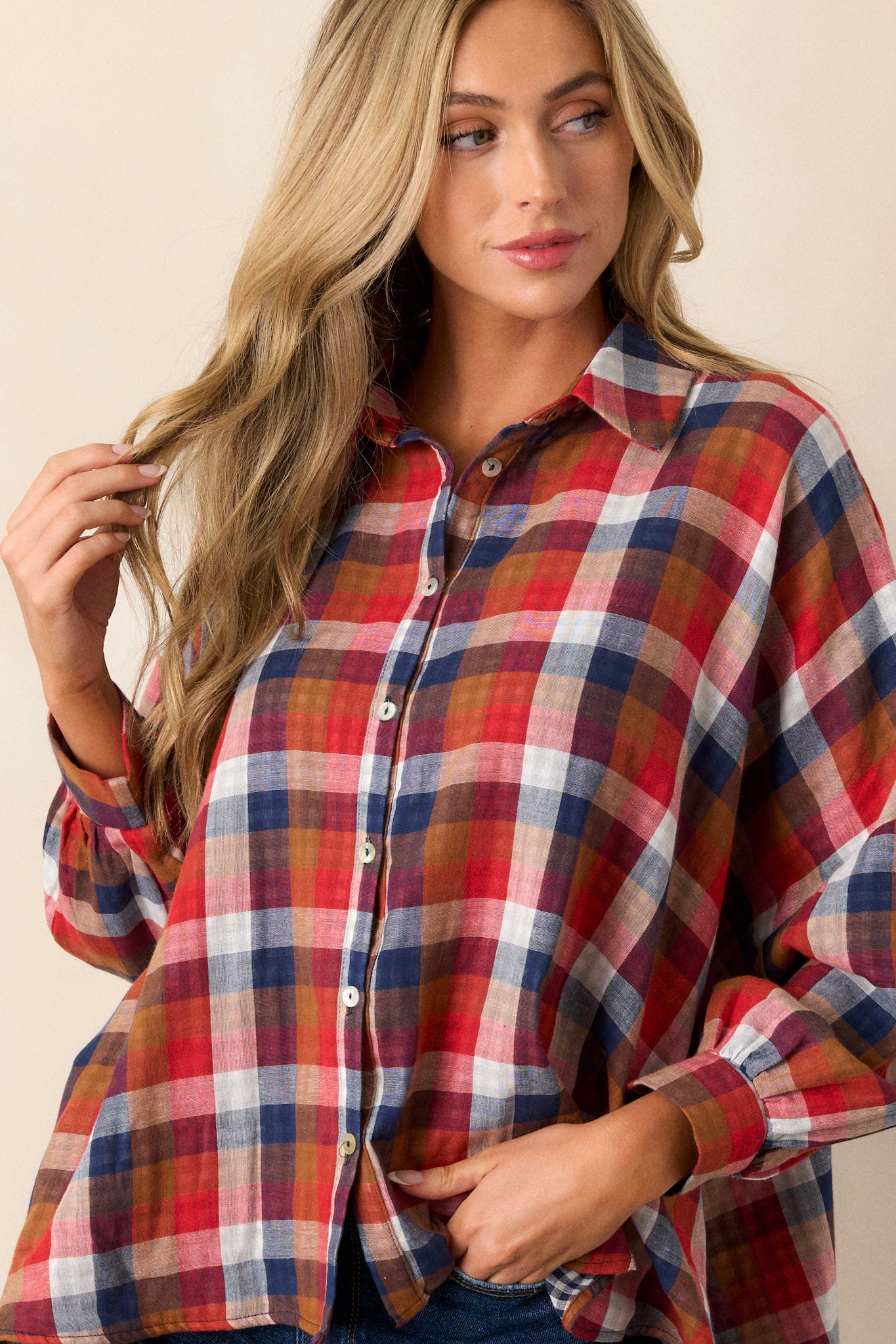 Front angled view of a top featuring a collared neckline, functional buttons down the front, cuffed sleeves with a different interior print, and an oversized fit