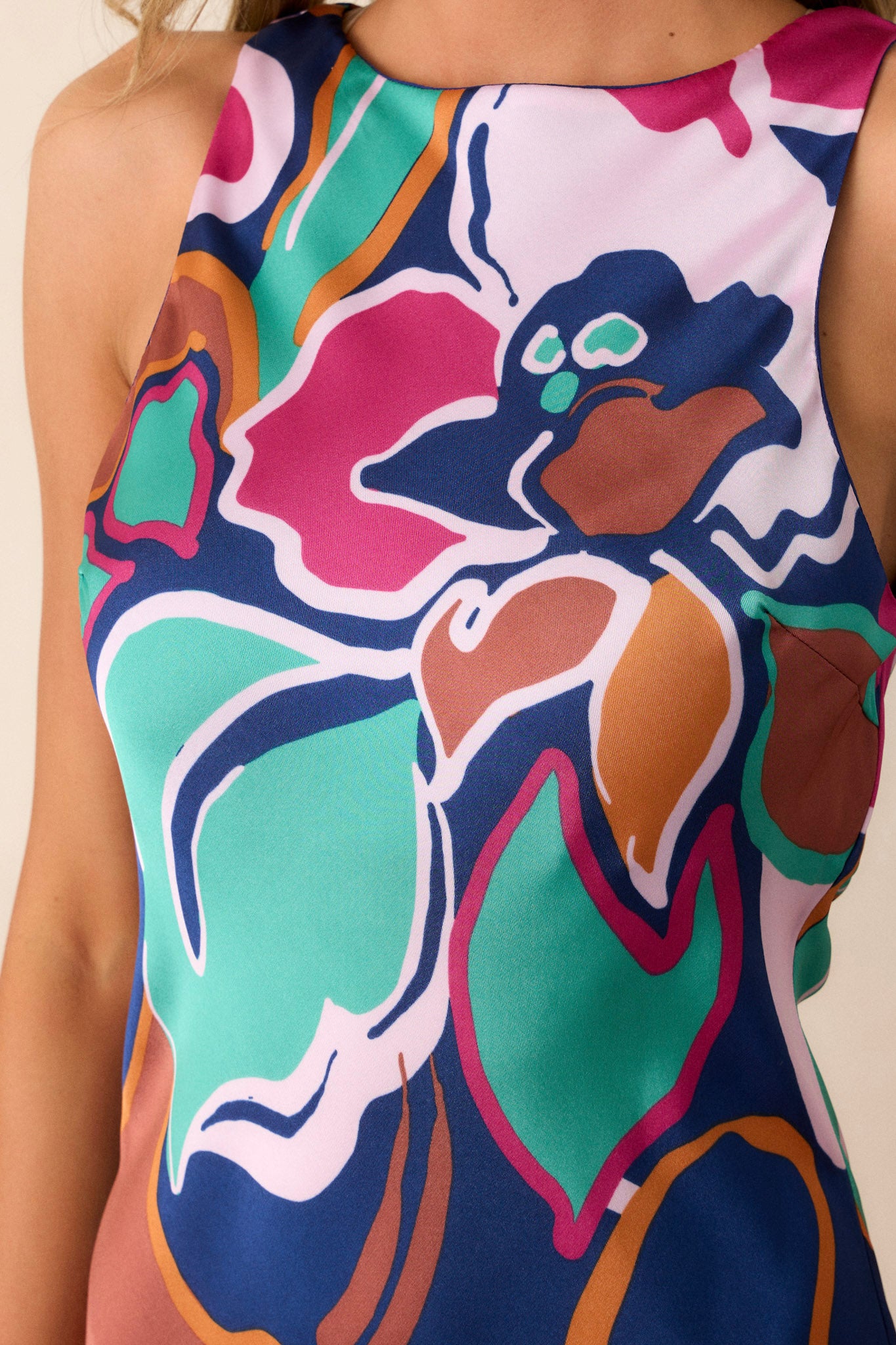 Close-up view of this midi dress that features a round neckline, a keyhole button closure, a unique abstract floral print, and a fun midi length.