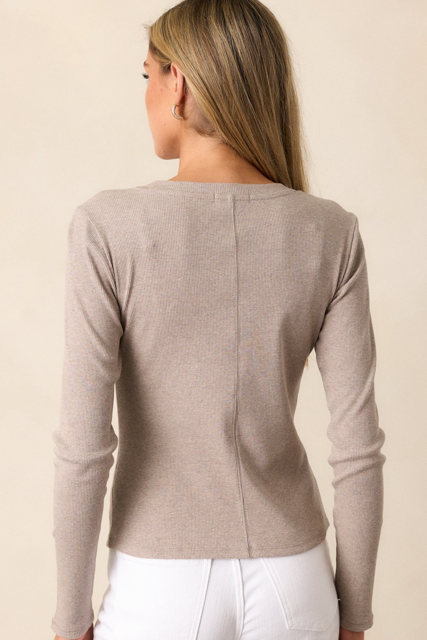 Back view of a taupe top highlighting the ribbed detailing and long sleeves.