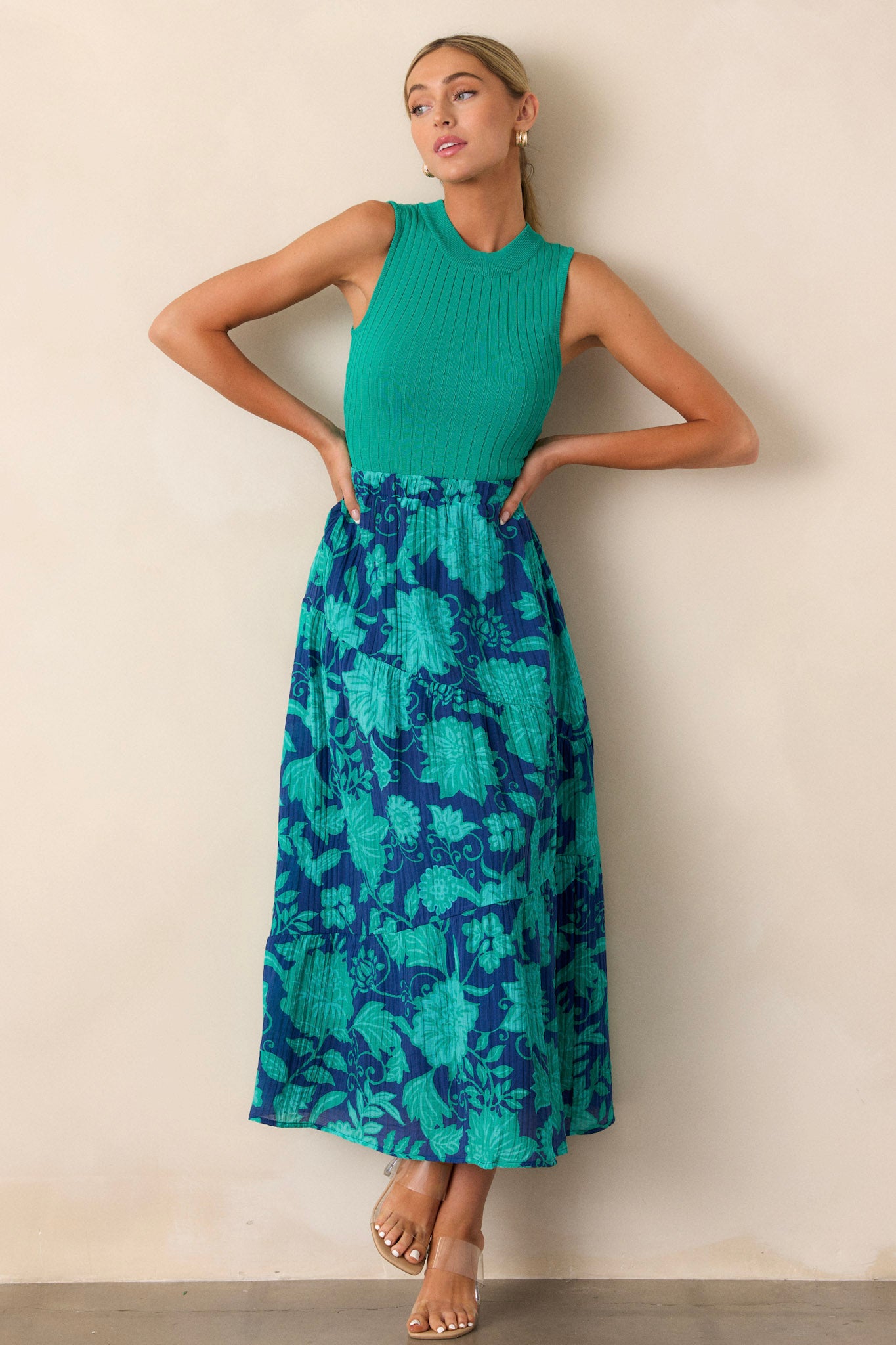 A navy skirt with an elastic waistband and green floral pattern, featuring an asymmetrical tiered design and textured gauze fabric, shown in full length.