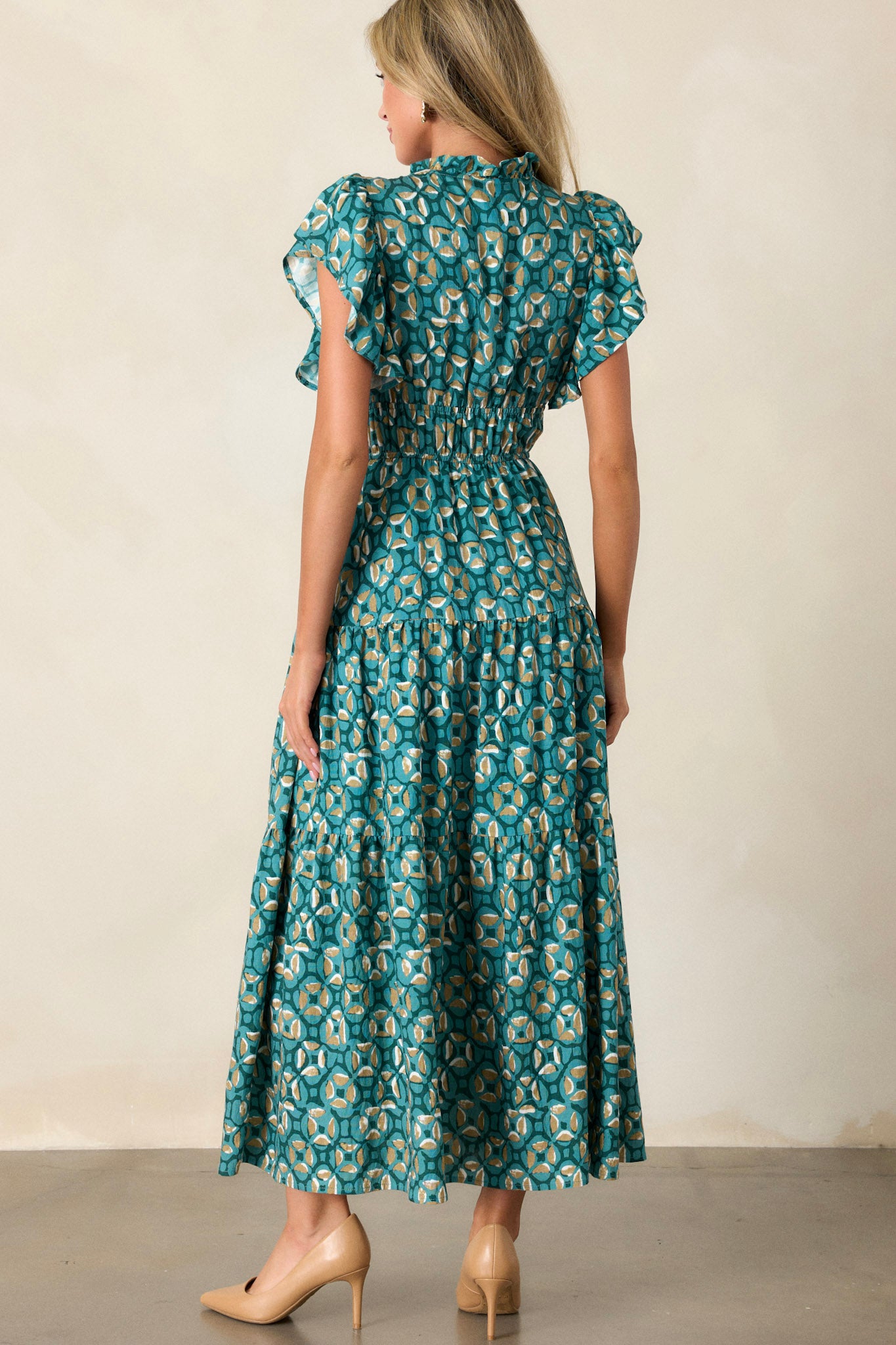 Back view of a green maxi dress highlighting the self-tie drawstring at the neckline, the tiered design, and the elastic waistband.