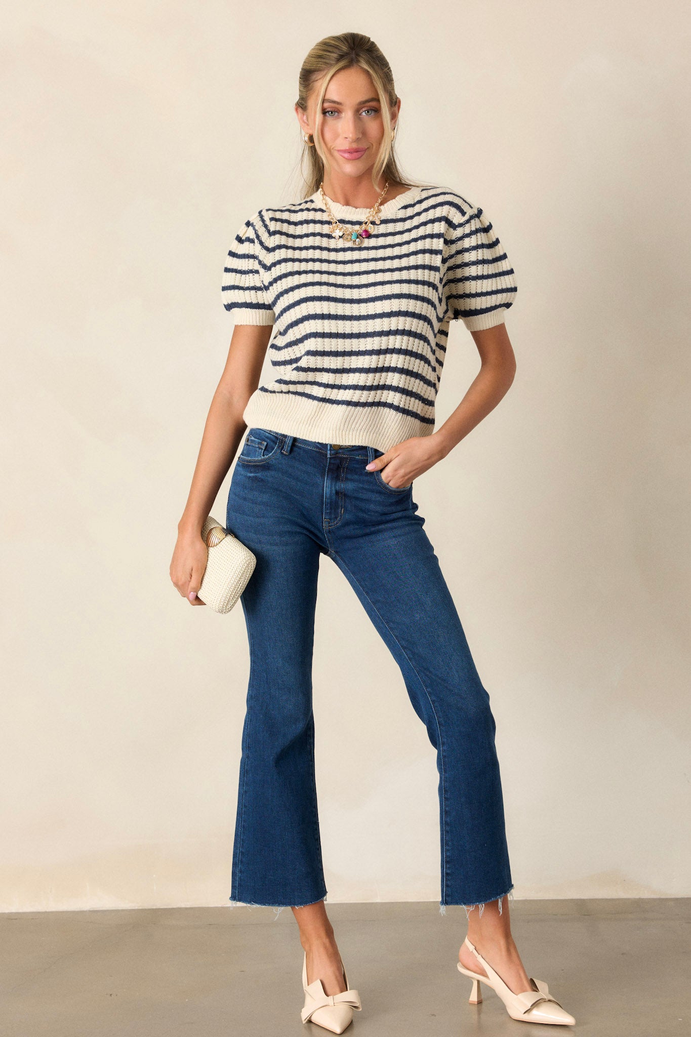 n ivory and navy striped knit top featuring a scalloped crew neckline, ribbed hems, short puff sleeves, and a slightly cropped fit, shown from the front.