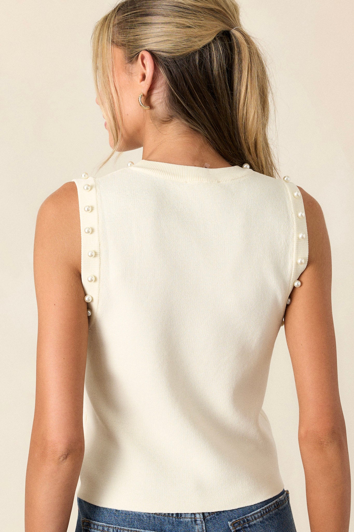 Back view of theivory tank top highlighting the clean back design and the slightly cropped hemline.