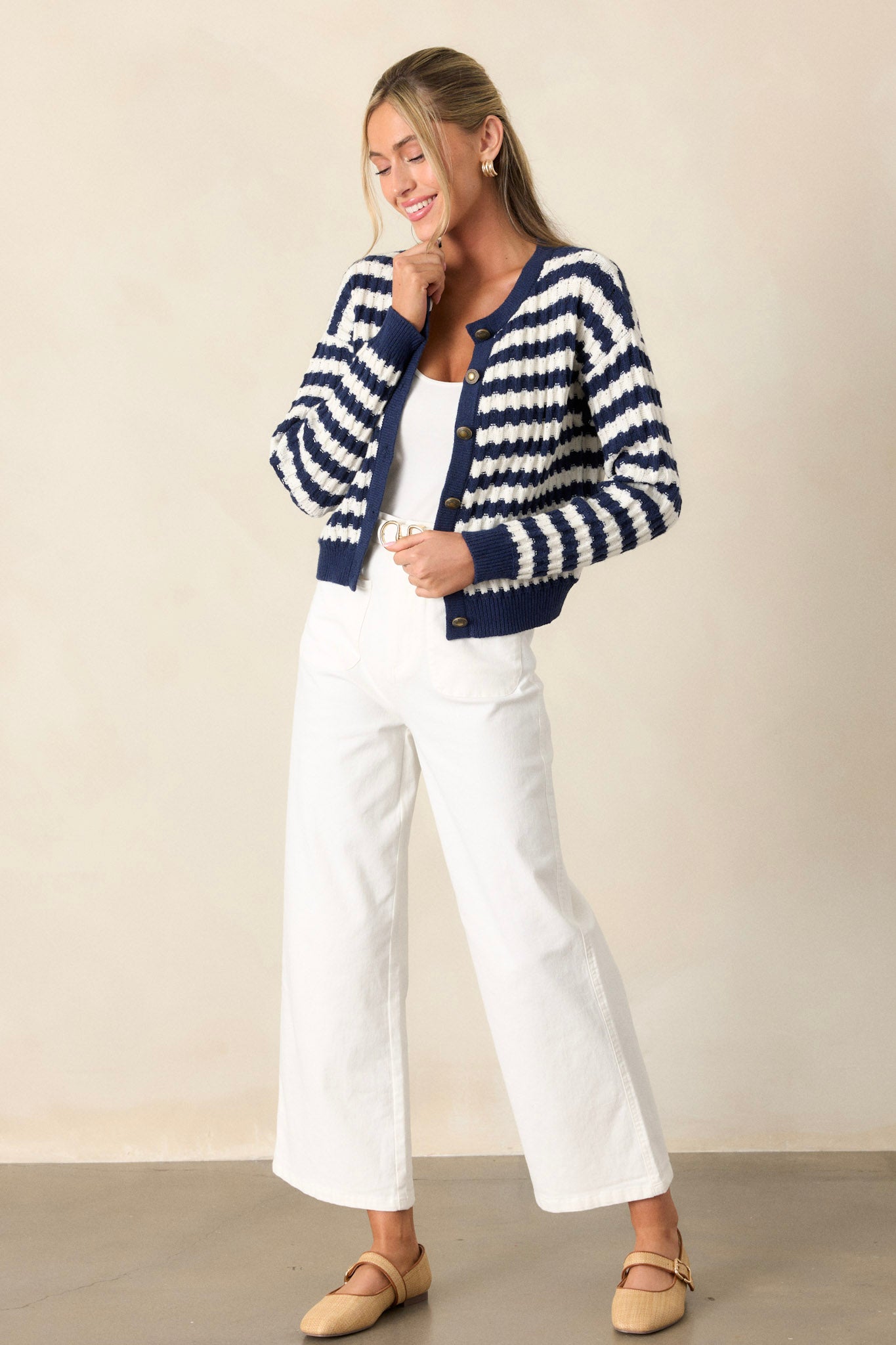 Full length view of the stripe sweater featuring a round neckline, horizontal stripe pattern, soft knit sweater texture, thick hemline, functional gold accent buttons, faux hip pockets, and cuffed long sleeves