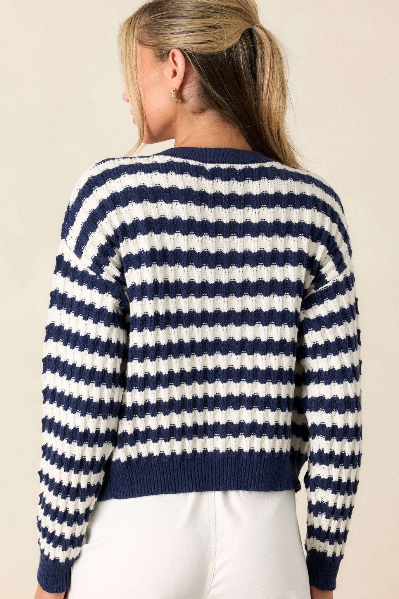 Back view of the stripe sweater highlighting the horizontal stripe pattern, soft knit texture, and cuffed long sleeves.