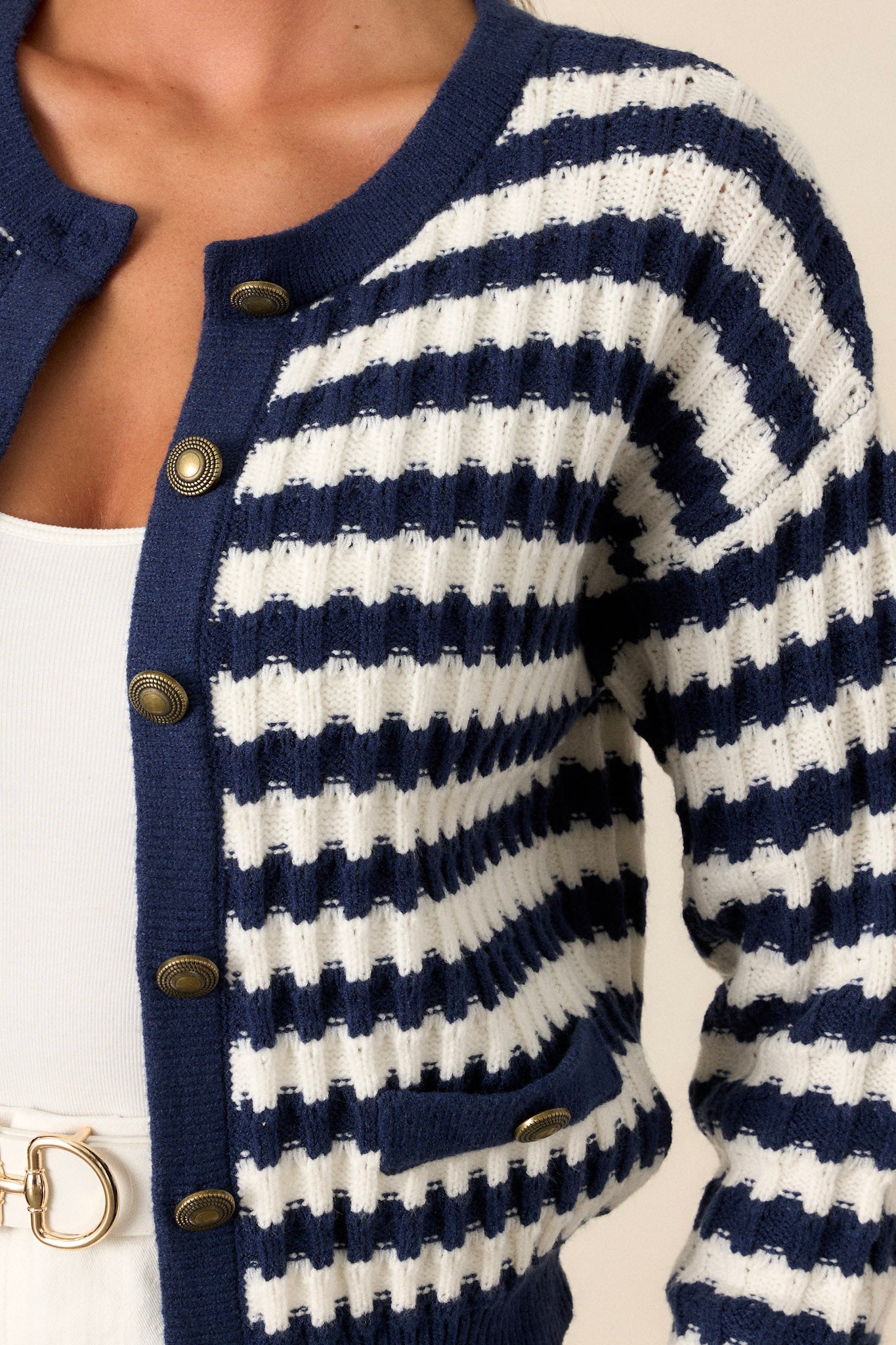 Close-up of the stripe sweater focusing on the functional gold accent buttons, faux hip pockets, and the texture of the soft knit fabric.