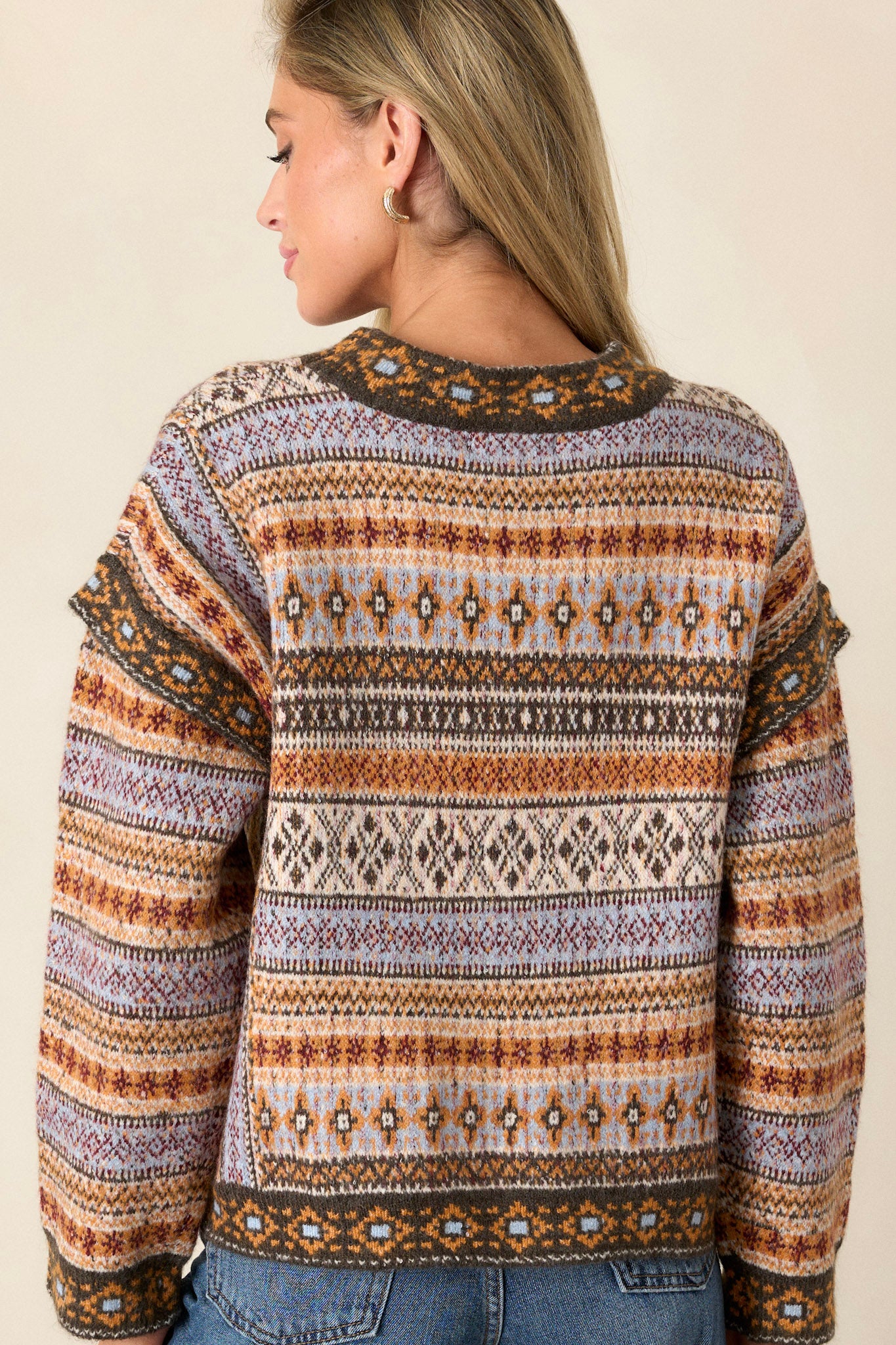 Back view of the sweater highlighting the continuation of the raw hems and the slightly cropped length, providing a clean finish