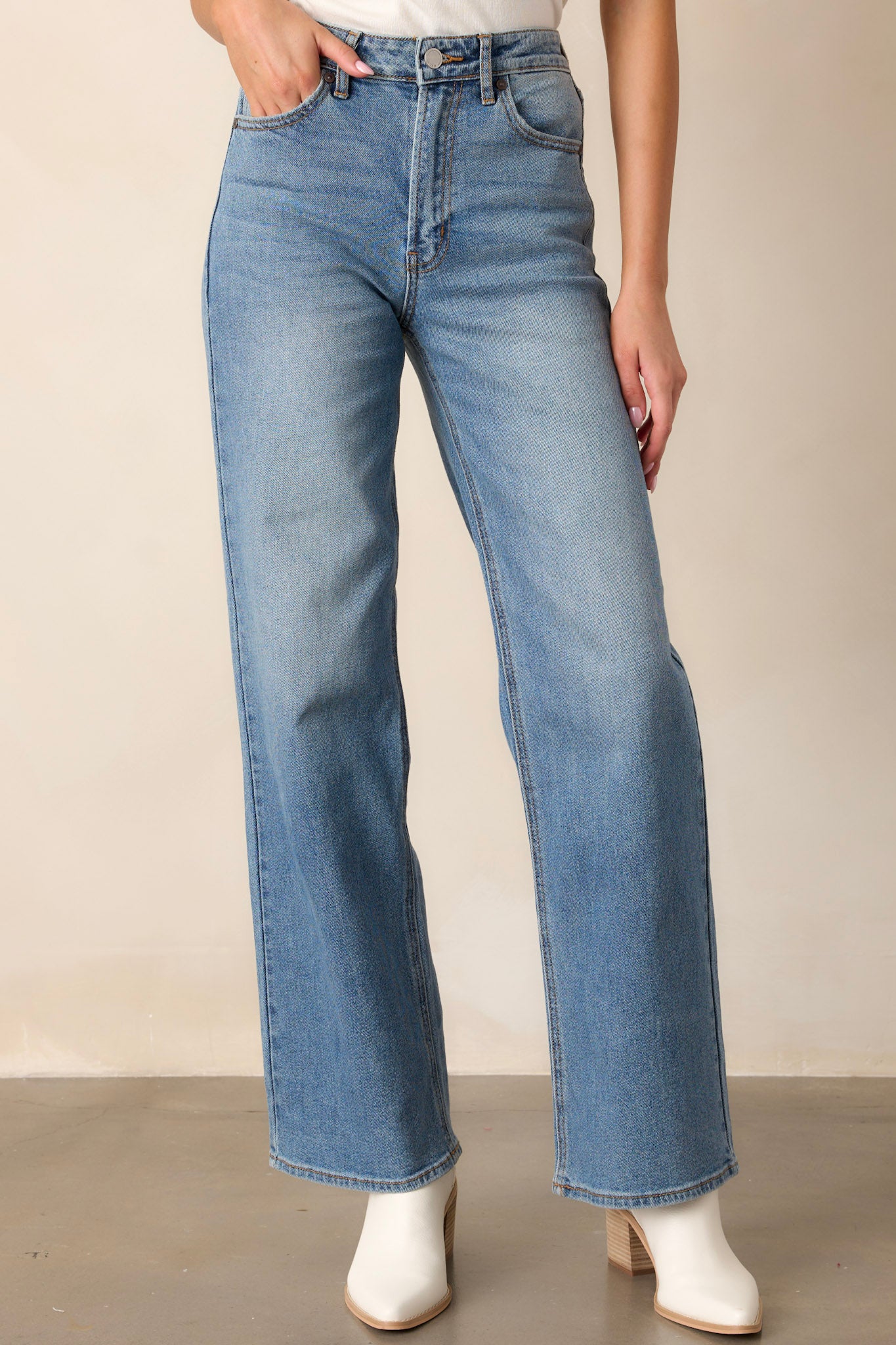 Front view of the jeans featuring functional belt loops, a button zipper closure, functional front pockets, and a wide leg design.