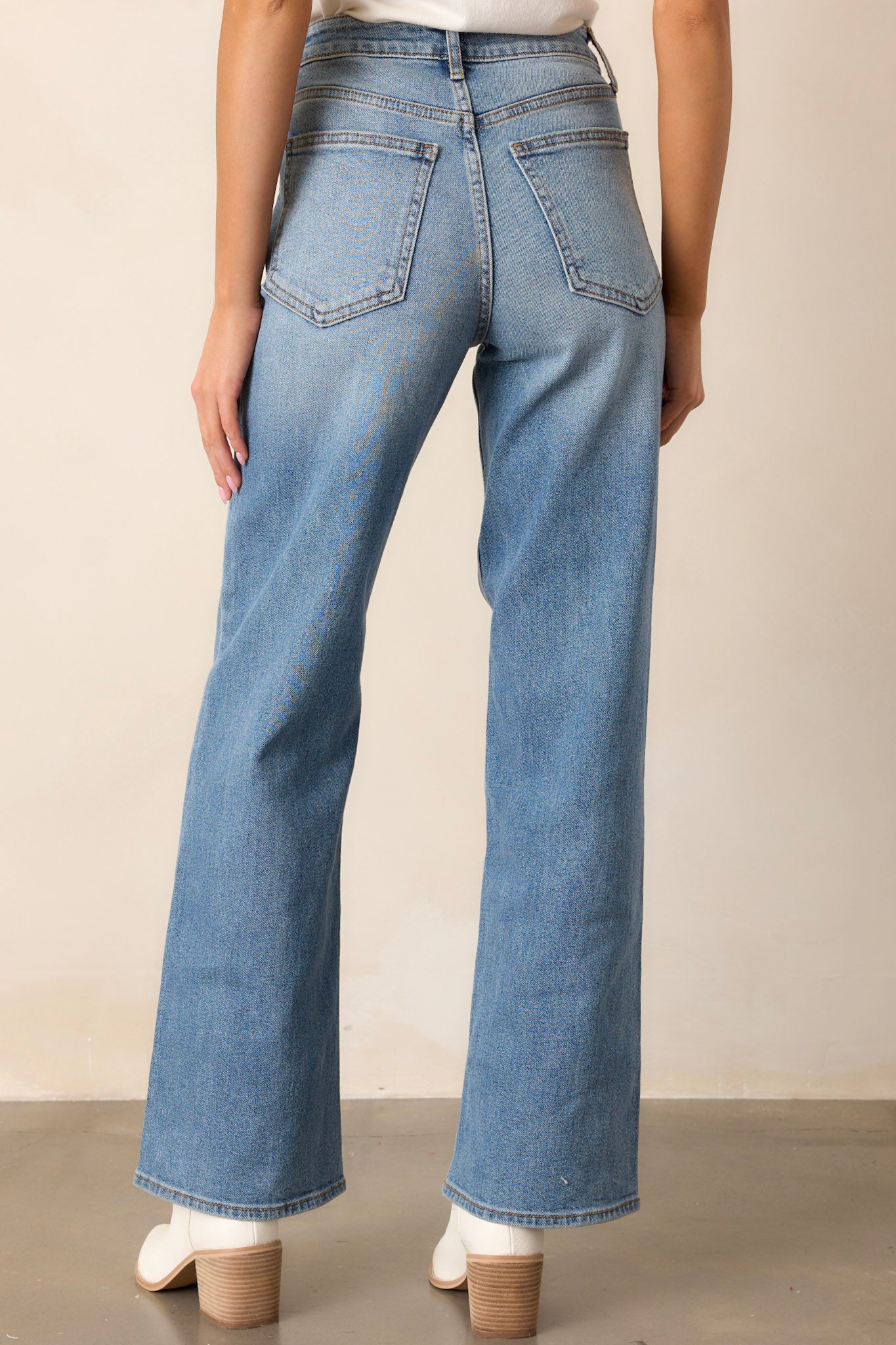 Back view of the jeans highlighting the functional back pockets, belt loops, and the wide leg design.