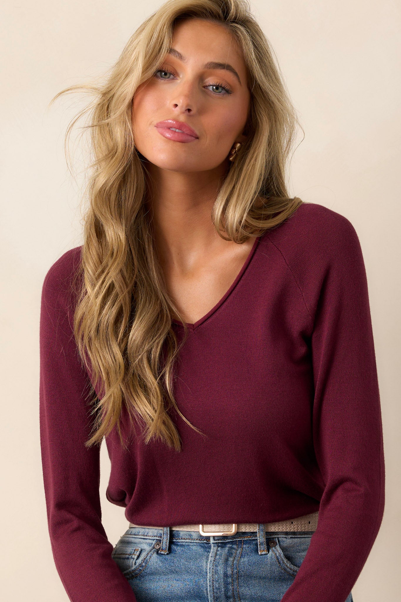 Close-up of the slight v-neckline with raw hem on soft knit top, highlighting delicate texture.