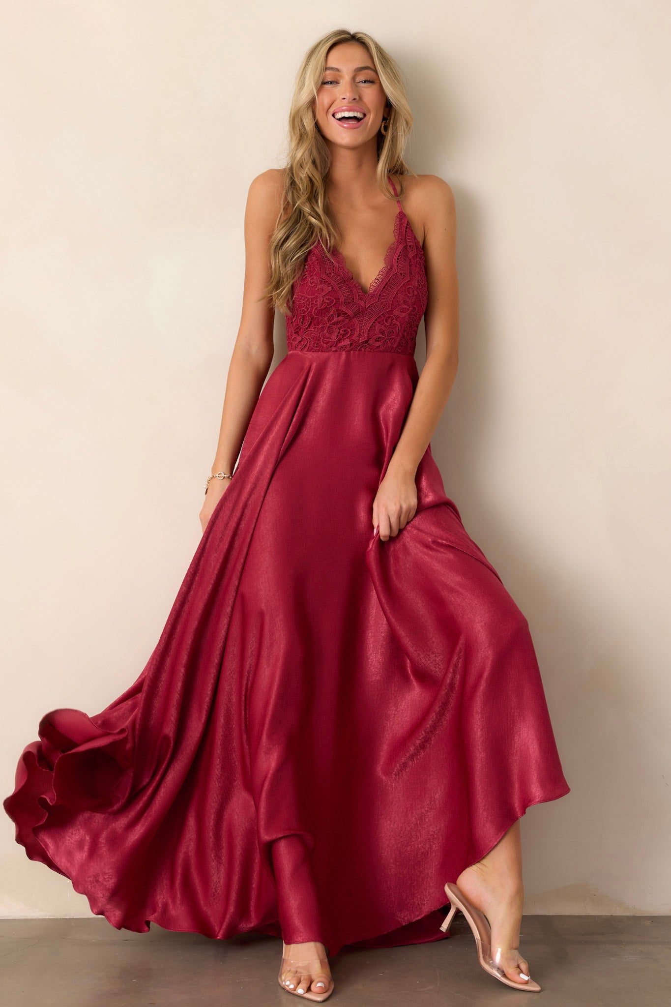 Front view of a cranberry dress featuring a v-neckline, intricate lace detailing on the bust, and a fitted silhouette.