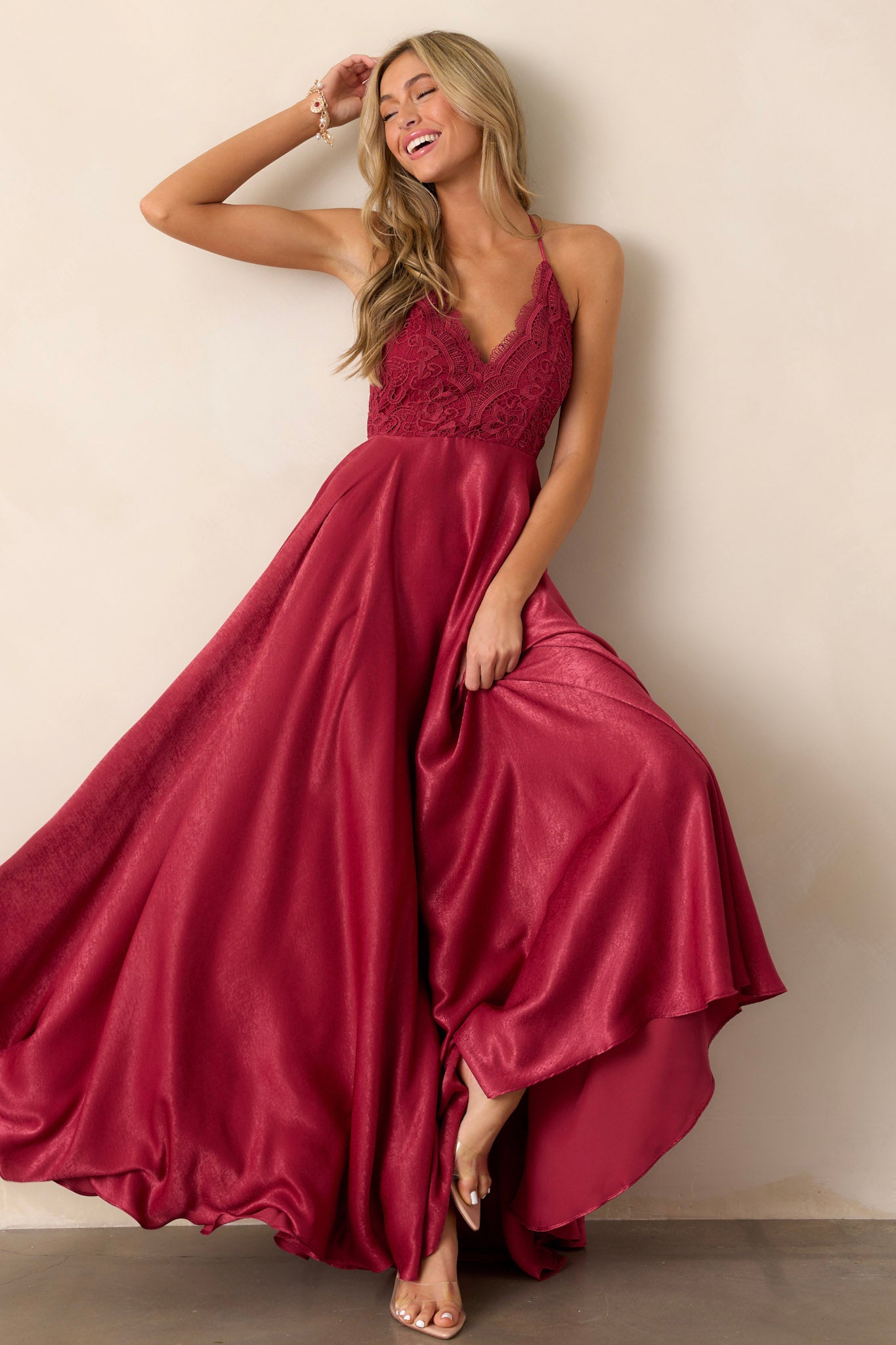 Action shot of the cranberry dress displaying the fluidity and elegance of the fabric, highlighting the v-neckline, lace detailing, and open back.