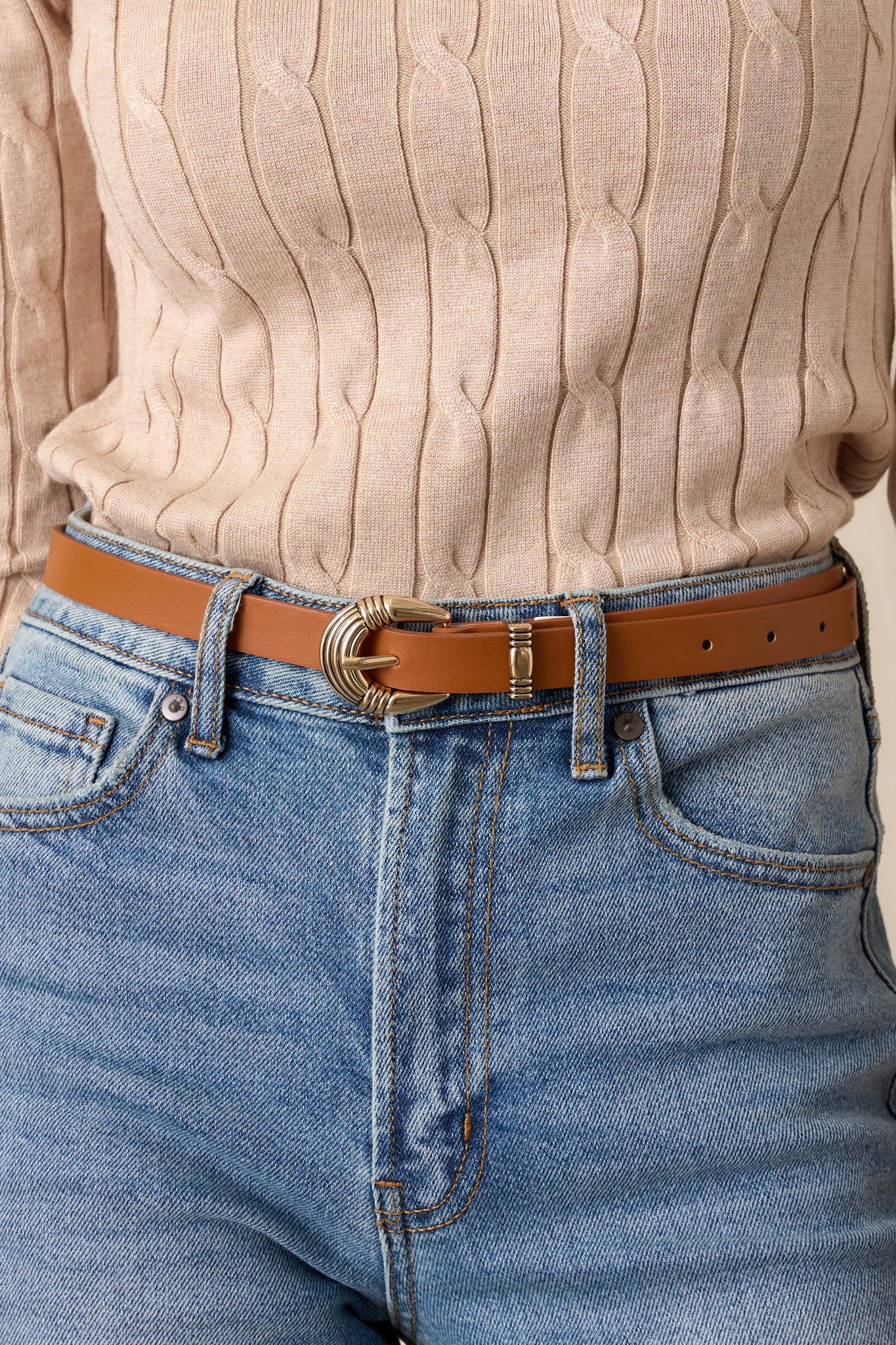 This belt features gold western style hardware with a sleek leather material.