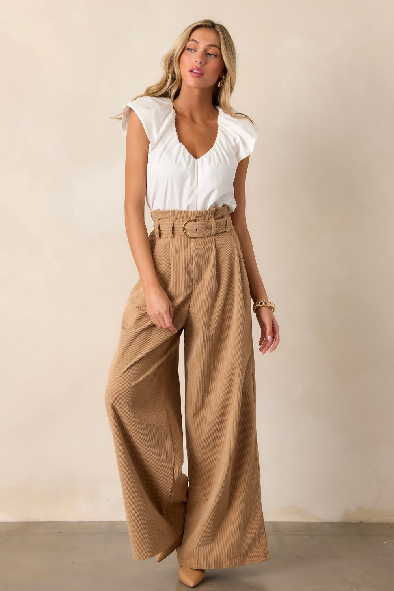 Full length view of a white top featuring a v-neckline, flutter sleeves, a casual fit, and a flowy design