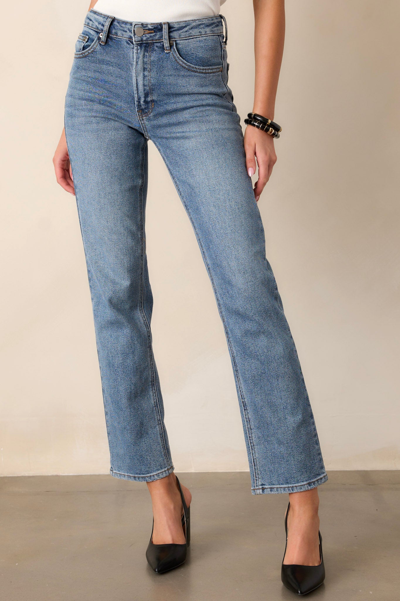 Front view of straight leg jeans featuring a high waisted design, functional belt loops, a button zipper closure, and functional hip pockets.