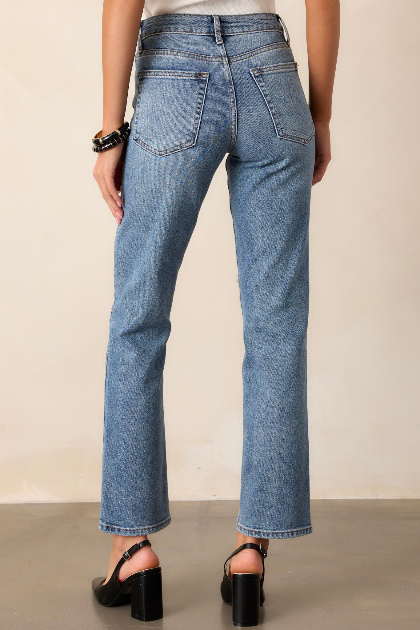 Back view of straight leg jeans highlighting the high waisted design, functional back pockets, and the straight leg cut.