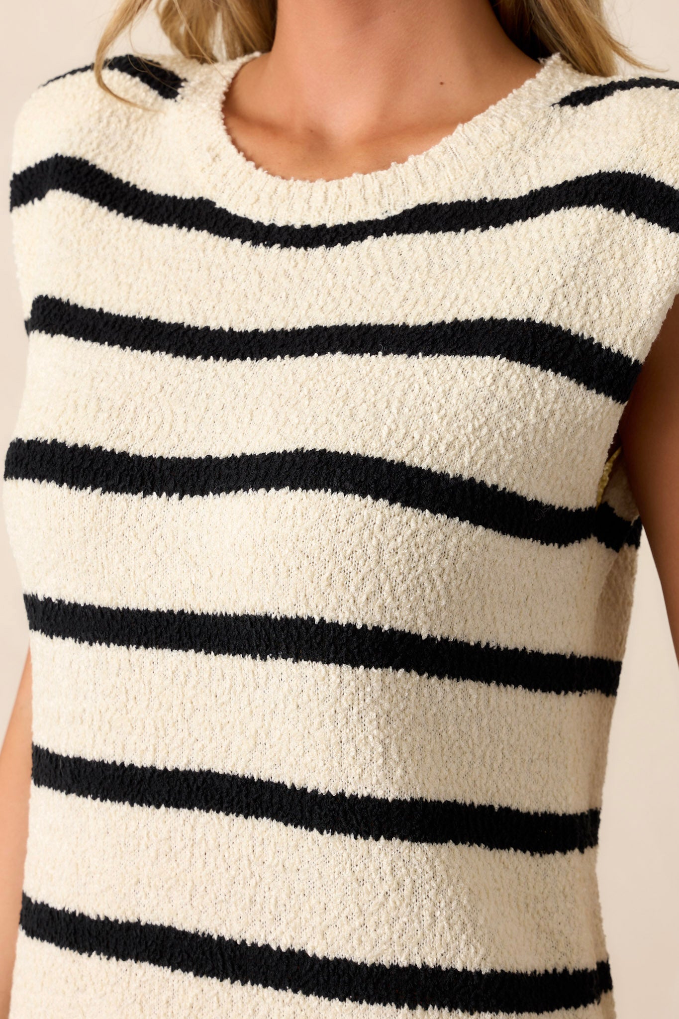 Close-up of the ivory dress focusing on the ribbed collar, shoulder pads, and the small leg slit.