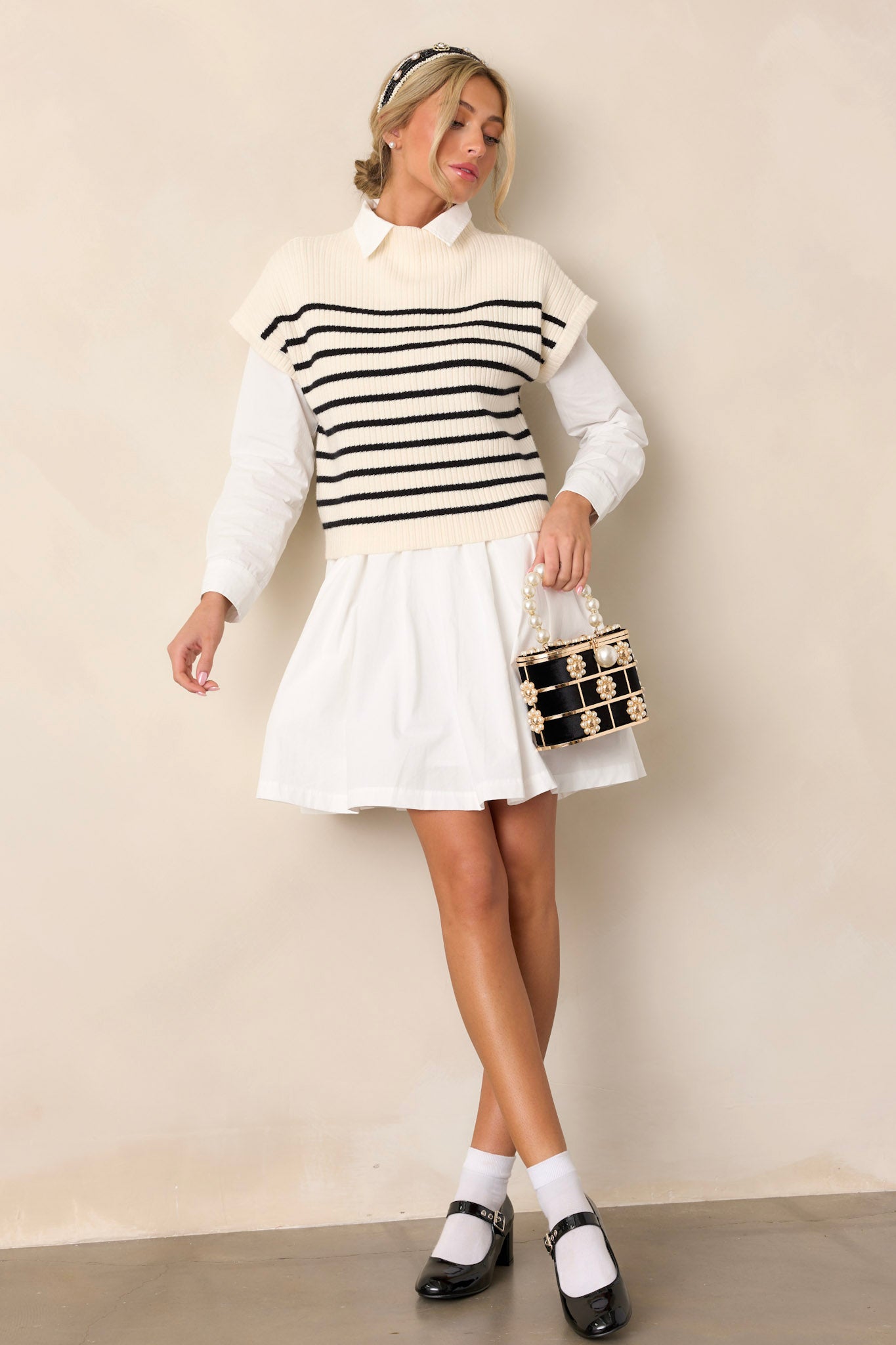 Full length view of an ivory stripe top featuring a high neckline, black horizontal stripe pattern, a soft thick knit material, and short sleeves