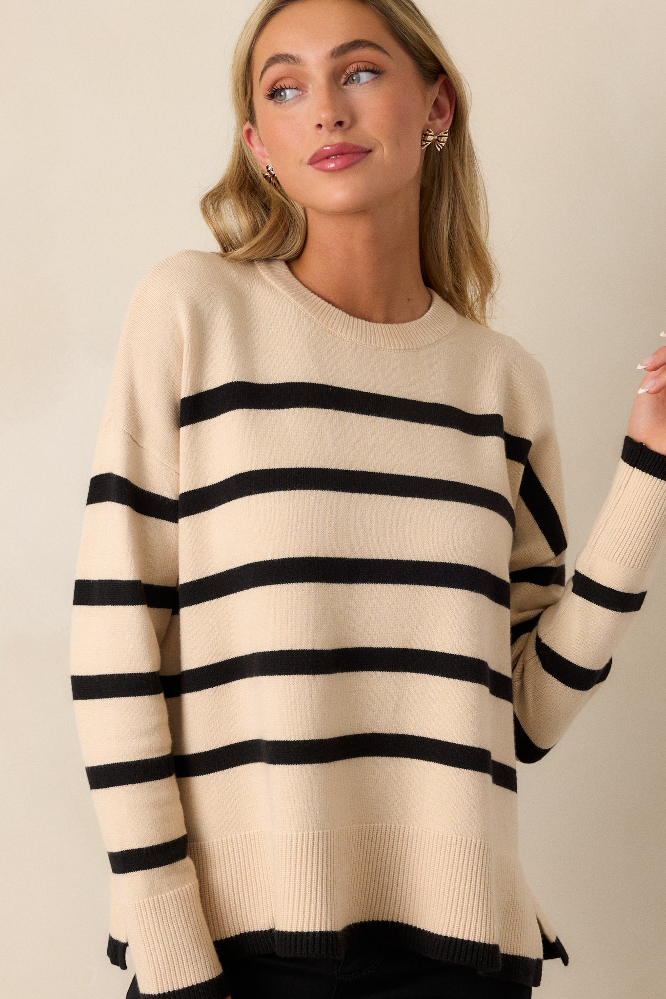 Cropped view emphasizing the ribbed crew neckline and upper section of the beige sweater, with the stripe pattern clearly visible.