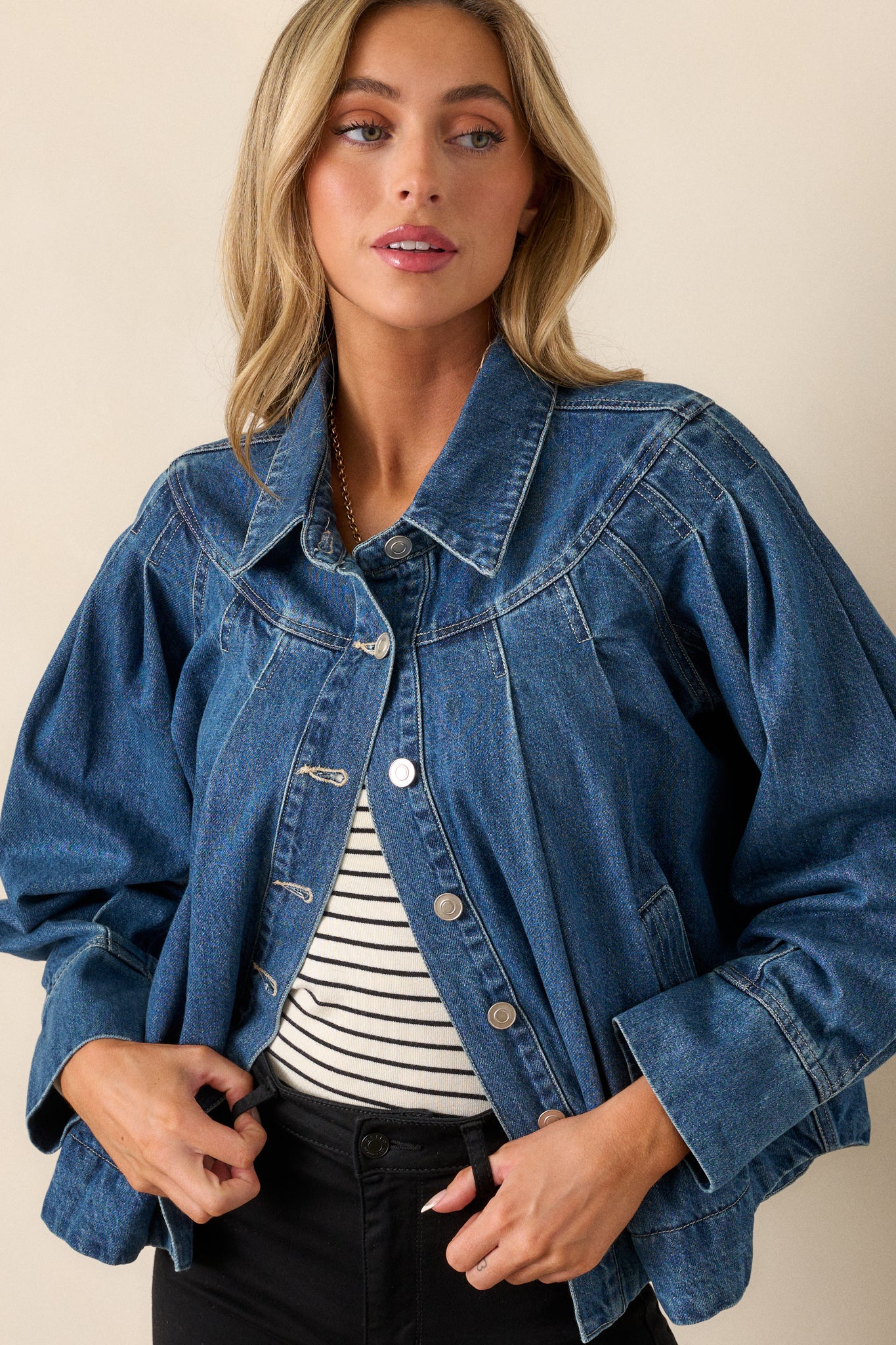 Cropped view focusing on the collar and upper portion of the denim jacket, highlighting the shoulder stitching and front buttons.