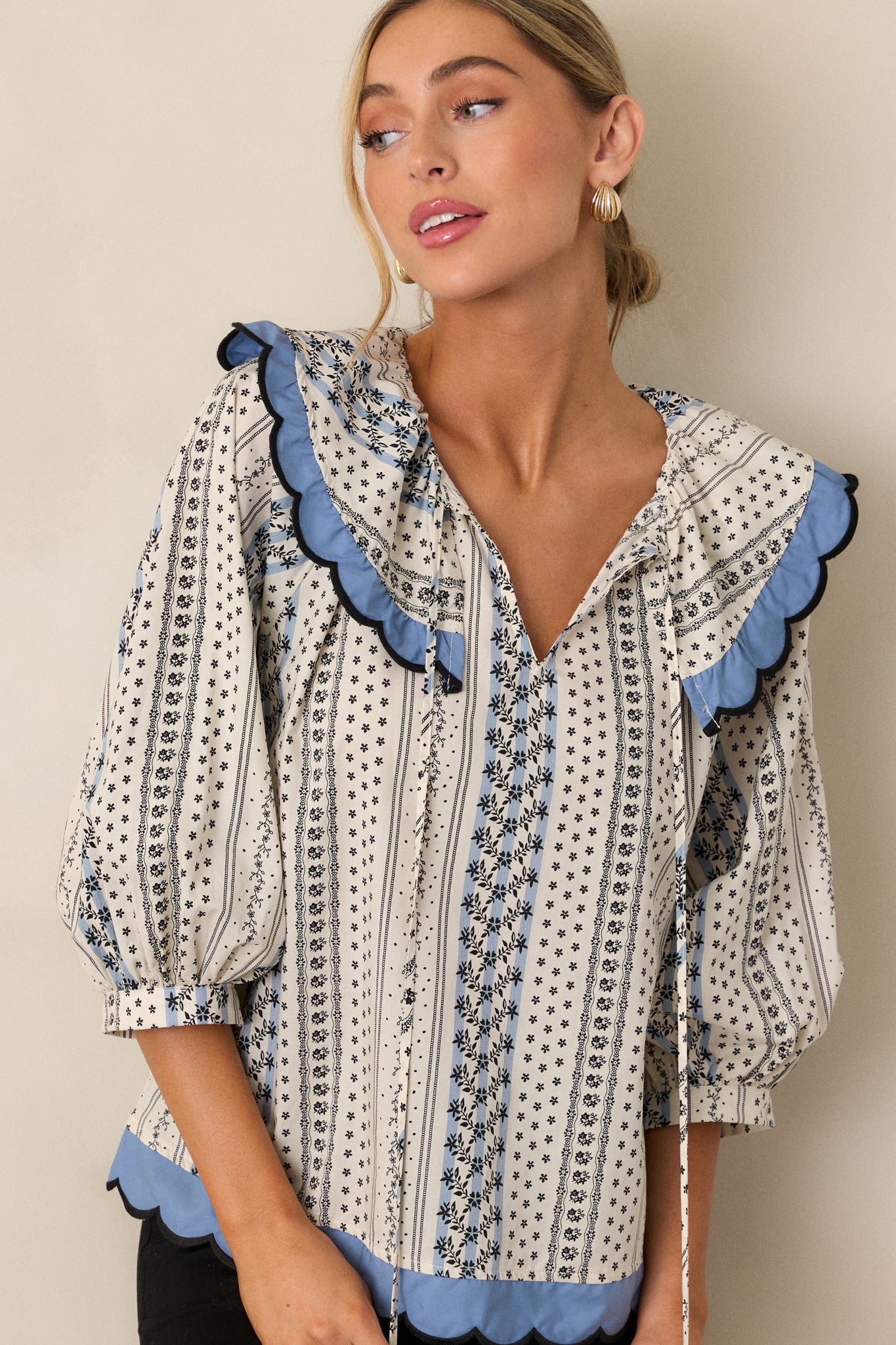 Close-up of the scallop collar neckline on the ivory top, showcasing the intricate floral stripe print near the neckline and upper bodice.