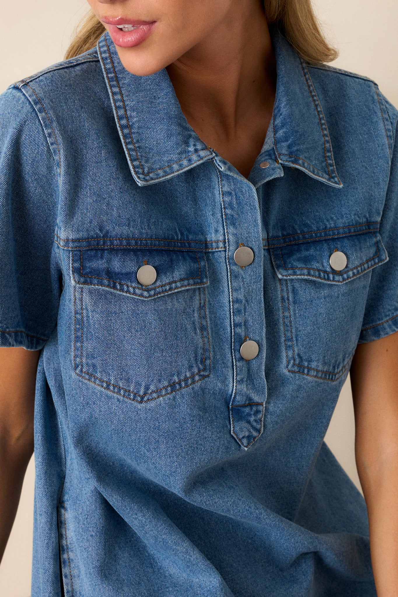 Close-up of the button front, showcasing the texture of the denim fabric and the details of the buttons and stitching.