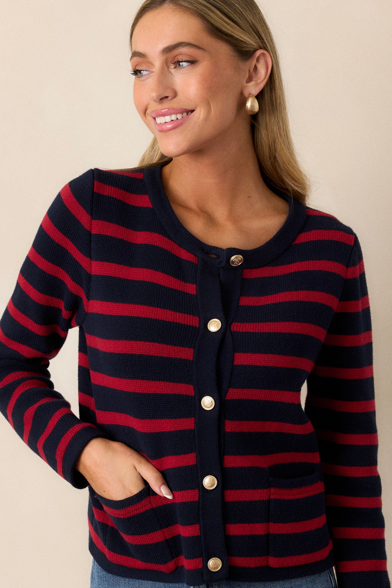 Front view of a cardigan featuring a crew neckline, a full button front with detailed gold buttons, and functional pockets.