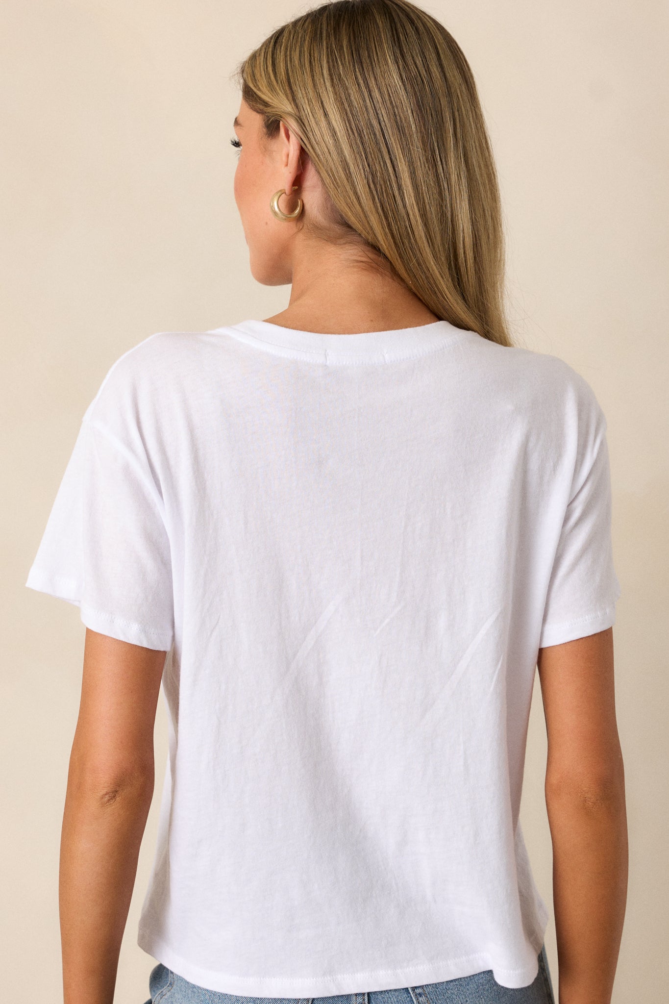 Back view of the white tee, showing the relaxed fit and smooth finish of the fabric from behind.