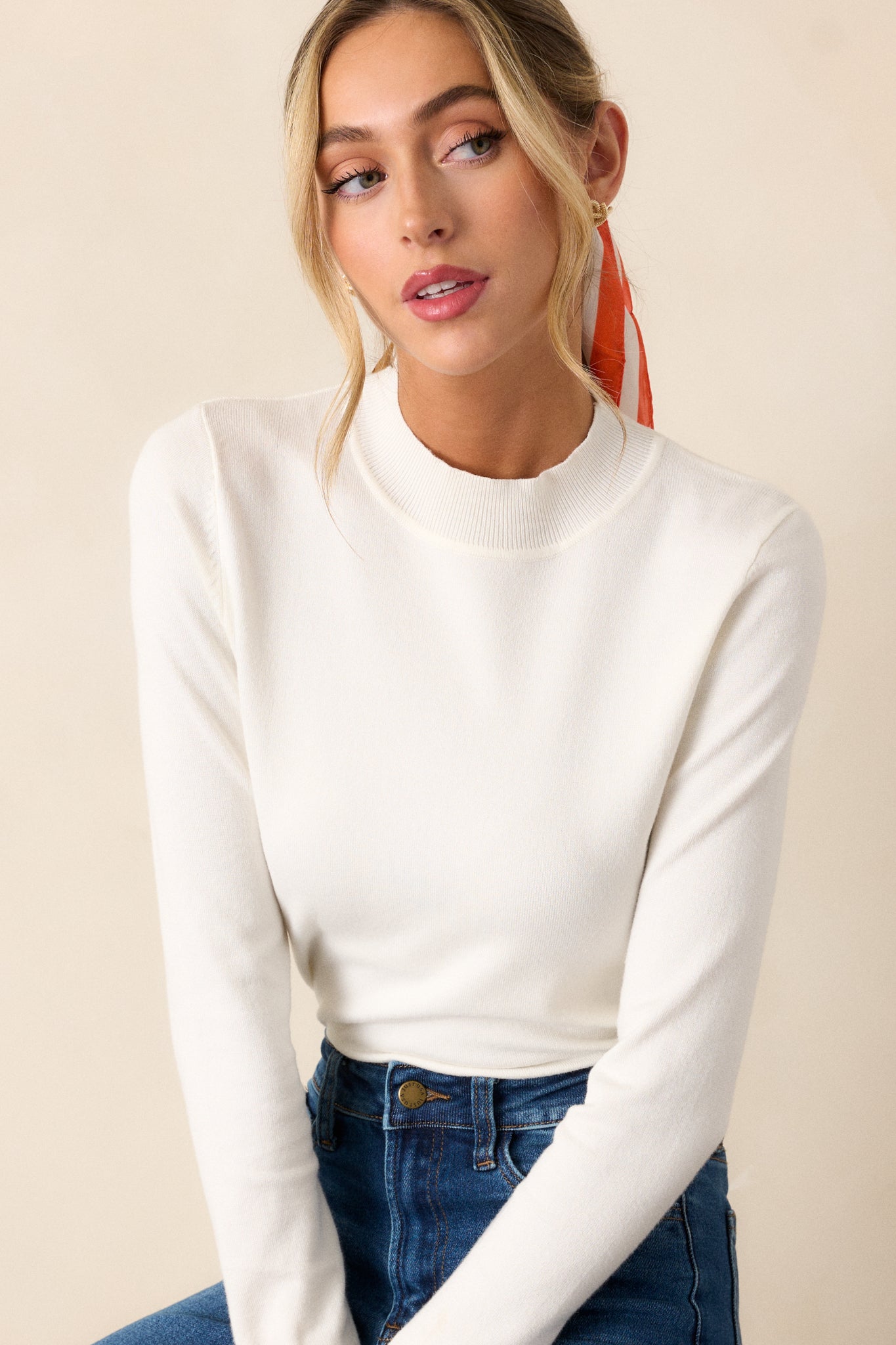 This ivory sweater top features a ribbed mock neckline, a light breathable fabric, a thick ribbed hemline and rib cuffed long sleeves.