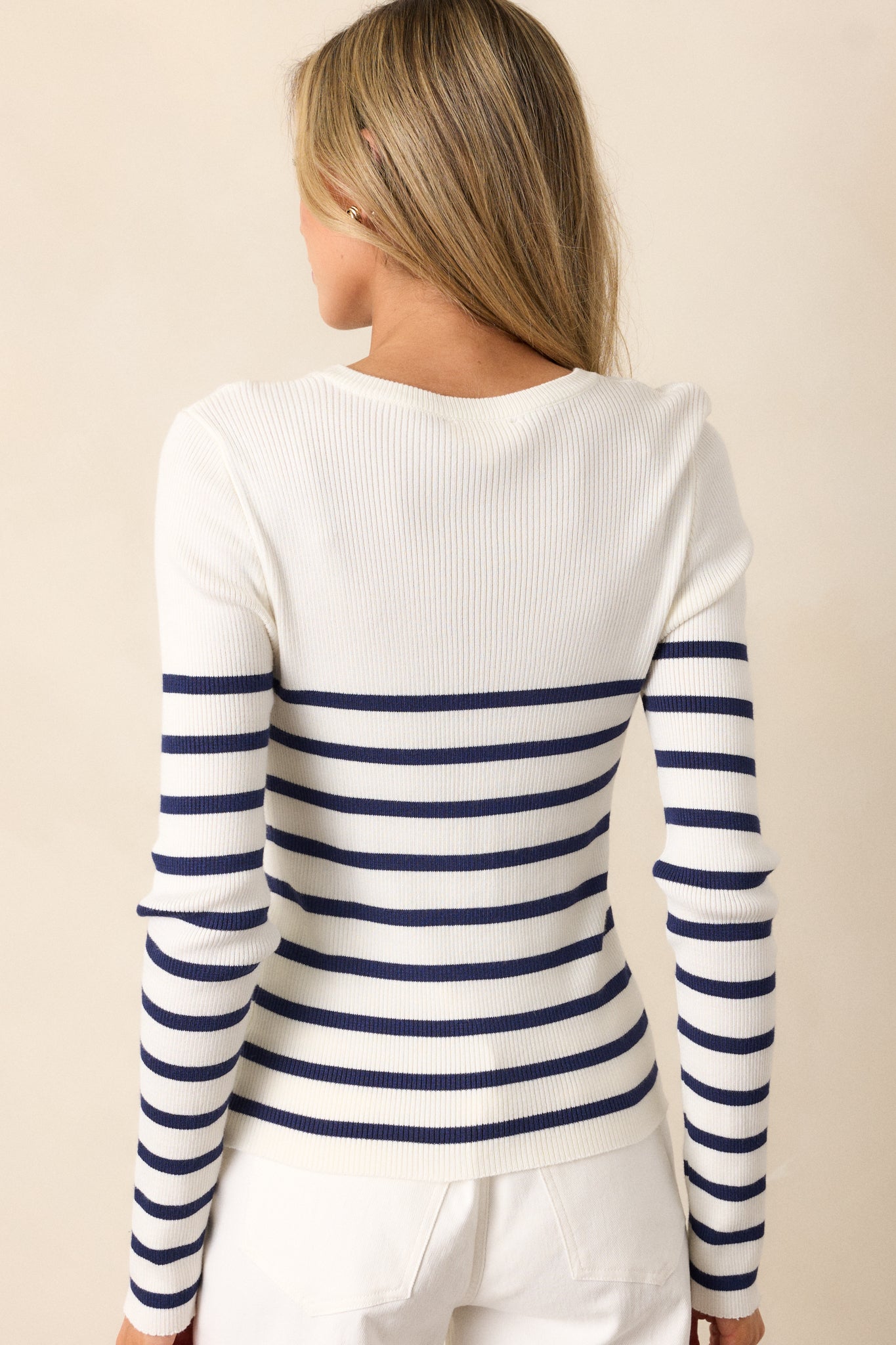 Back view of a navy stripe white top highlighting the overall fit, striped pattern, and long sleeves.