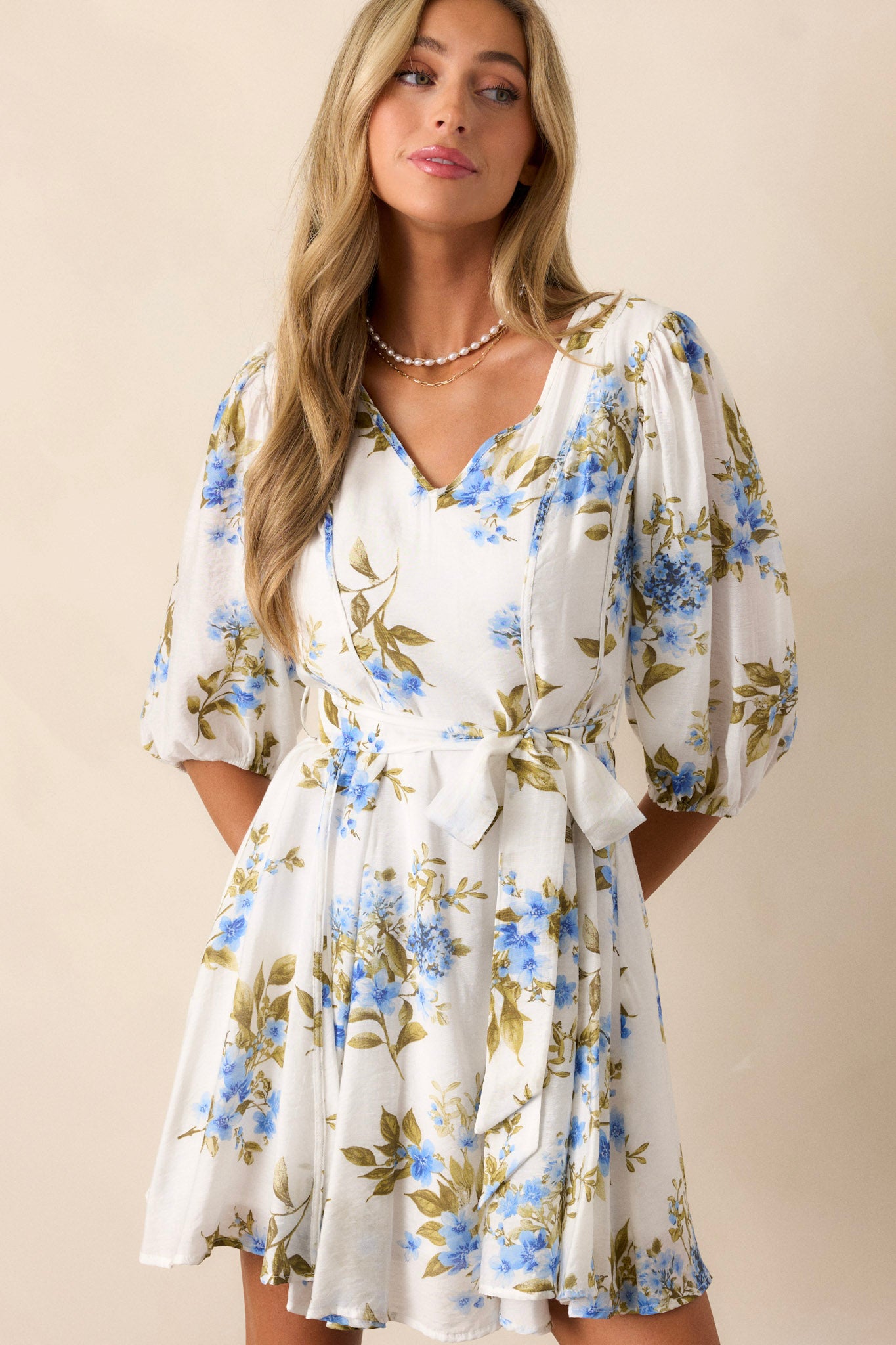 Front view of this blue & white floral dress, showcasing the blue flowers and green leaves against the white fabric.