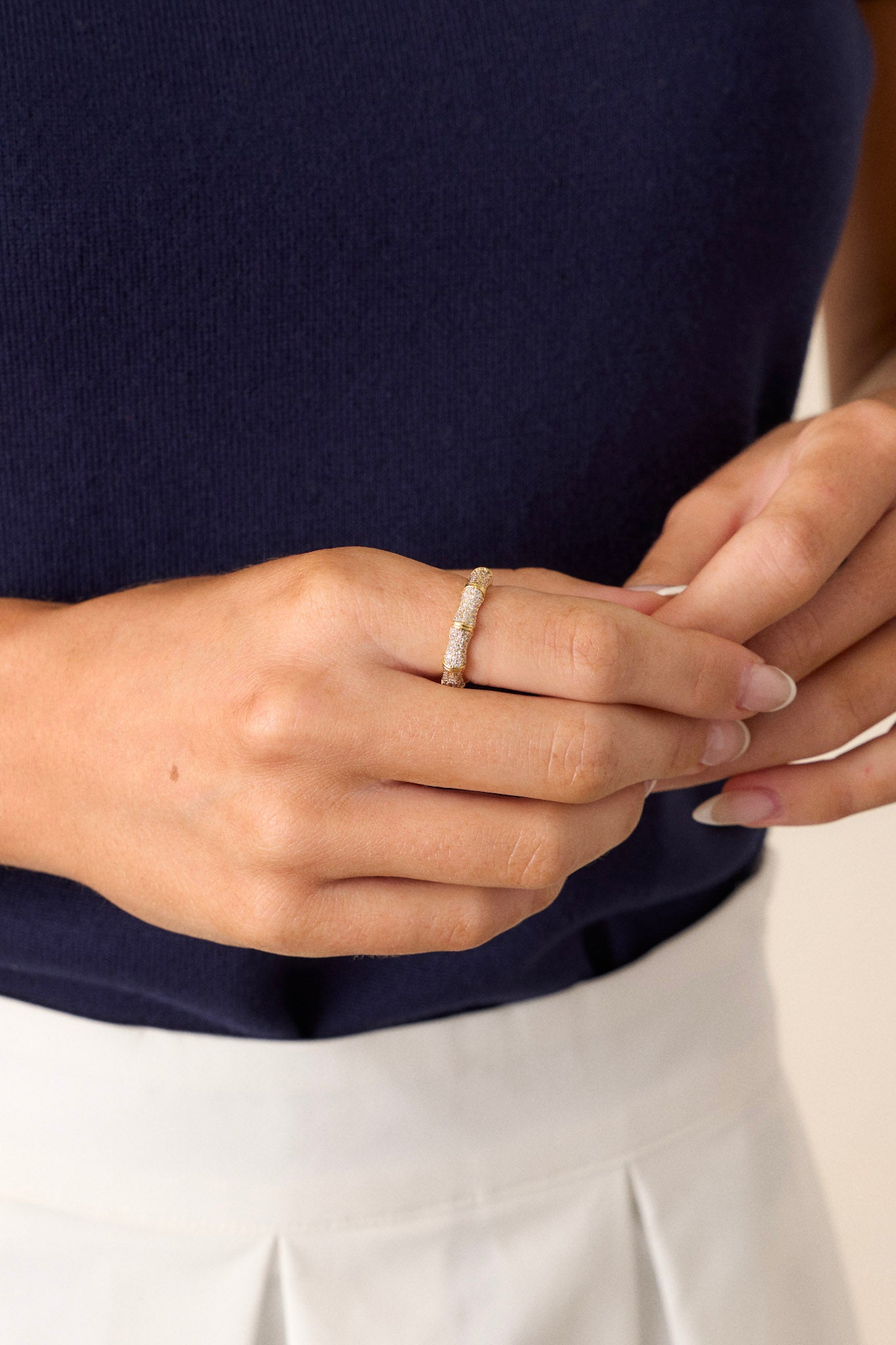 A cropped view of the gold ring, highlighting the large ridges in the design and the sparkling tiny rhinestones scattered throughout.