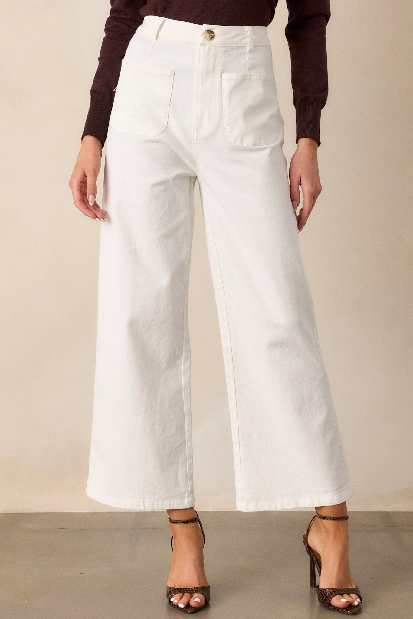 Close-up of the ivory jeans showing the classic button & zipper closure, belt loops, and functional front pockets.