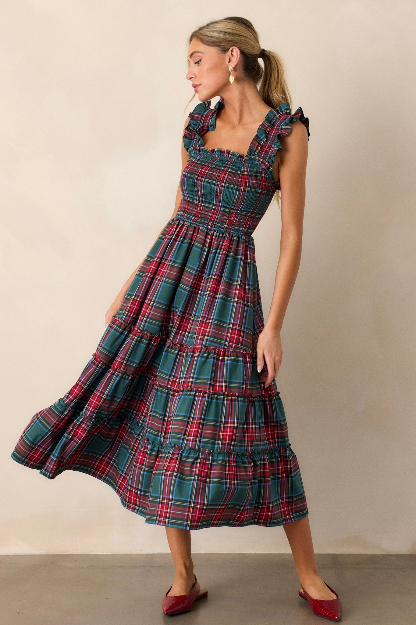 Full body view of this dress that features thick ruffle straps, smocked bodice, and a tiered skirt. 