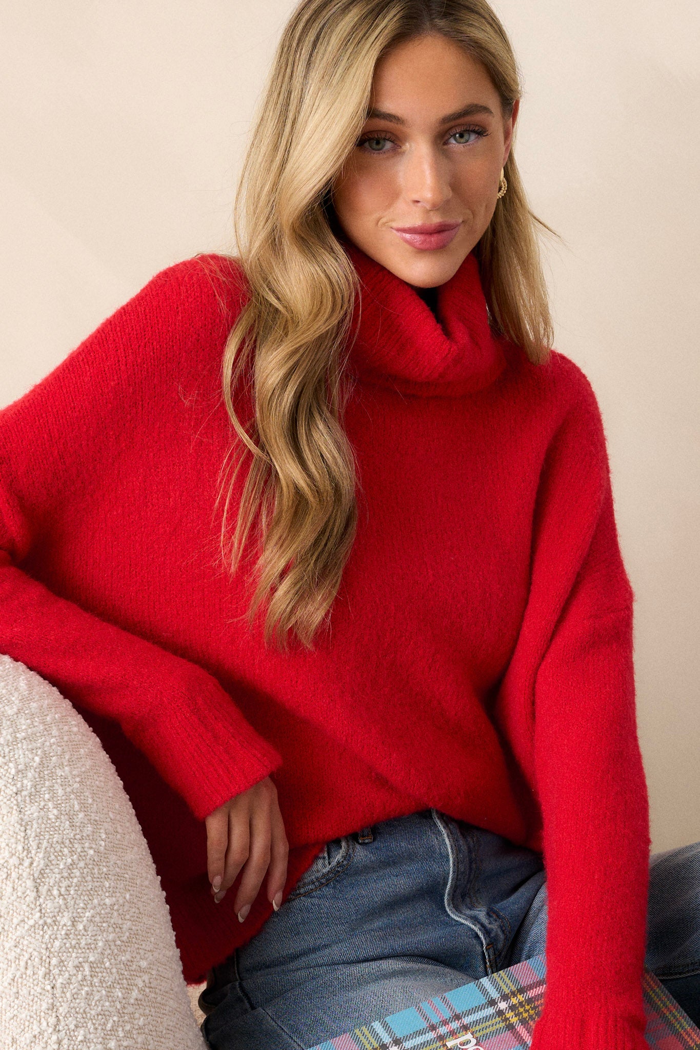 Full body view of this sweater that features a very light eyelash knit design, a turtle cowl neckline, extremely dropped shoulders, and a slight high low hemline.