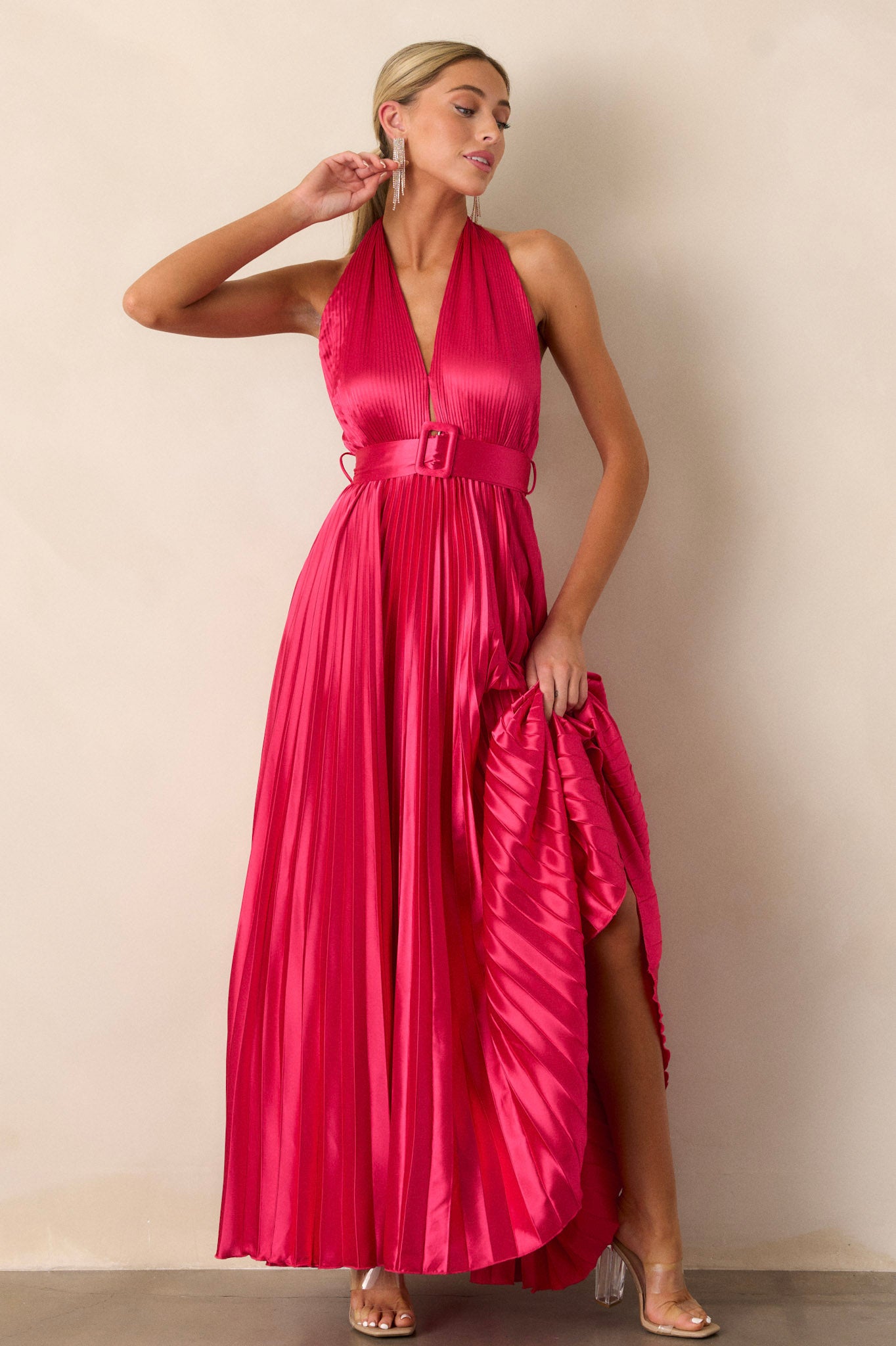 Action shot of the magenta pink dress displaying the flow and movement of the pleated fabric, highlighting the halter neck tie and the cinched waist with the functional belt.