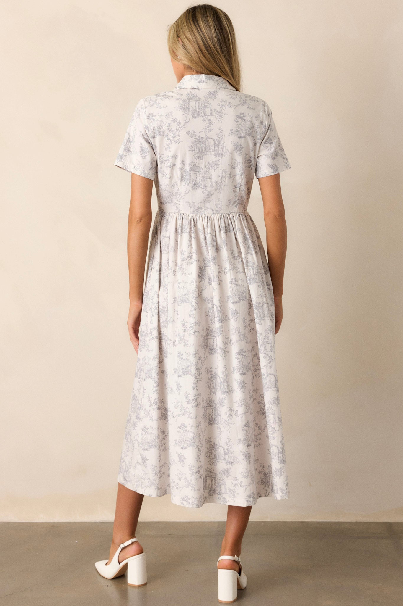 Back view of a light grey maxi dress highlighting the overall fit, collared neckline, and flowing silhouette.