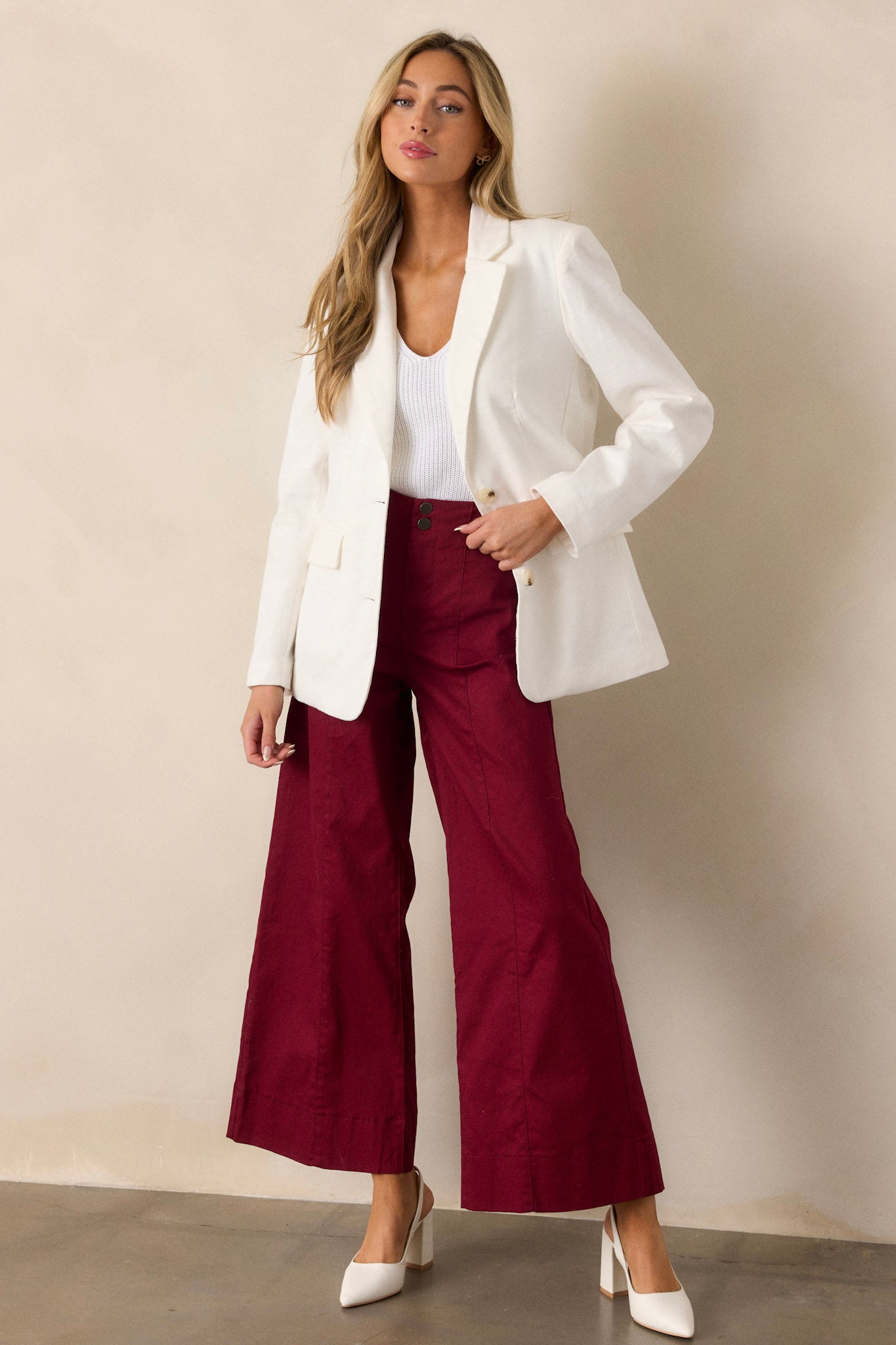 These burgundy pants feature a high waisted design, a button zipper closure, functional rectangular hip pockets and a wide leg.