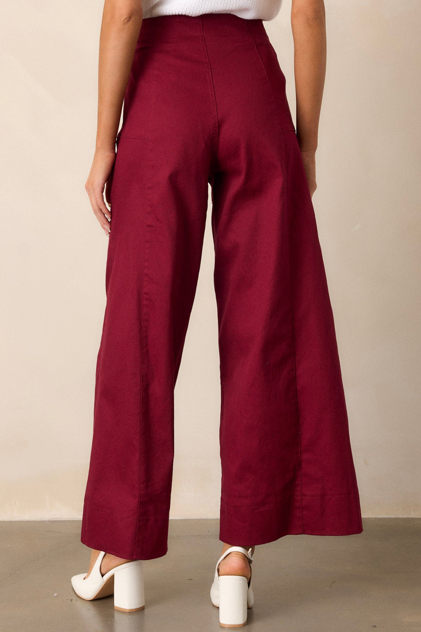 Back view of burgundy pants highlighting the high waisted design and the wide leg cut.