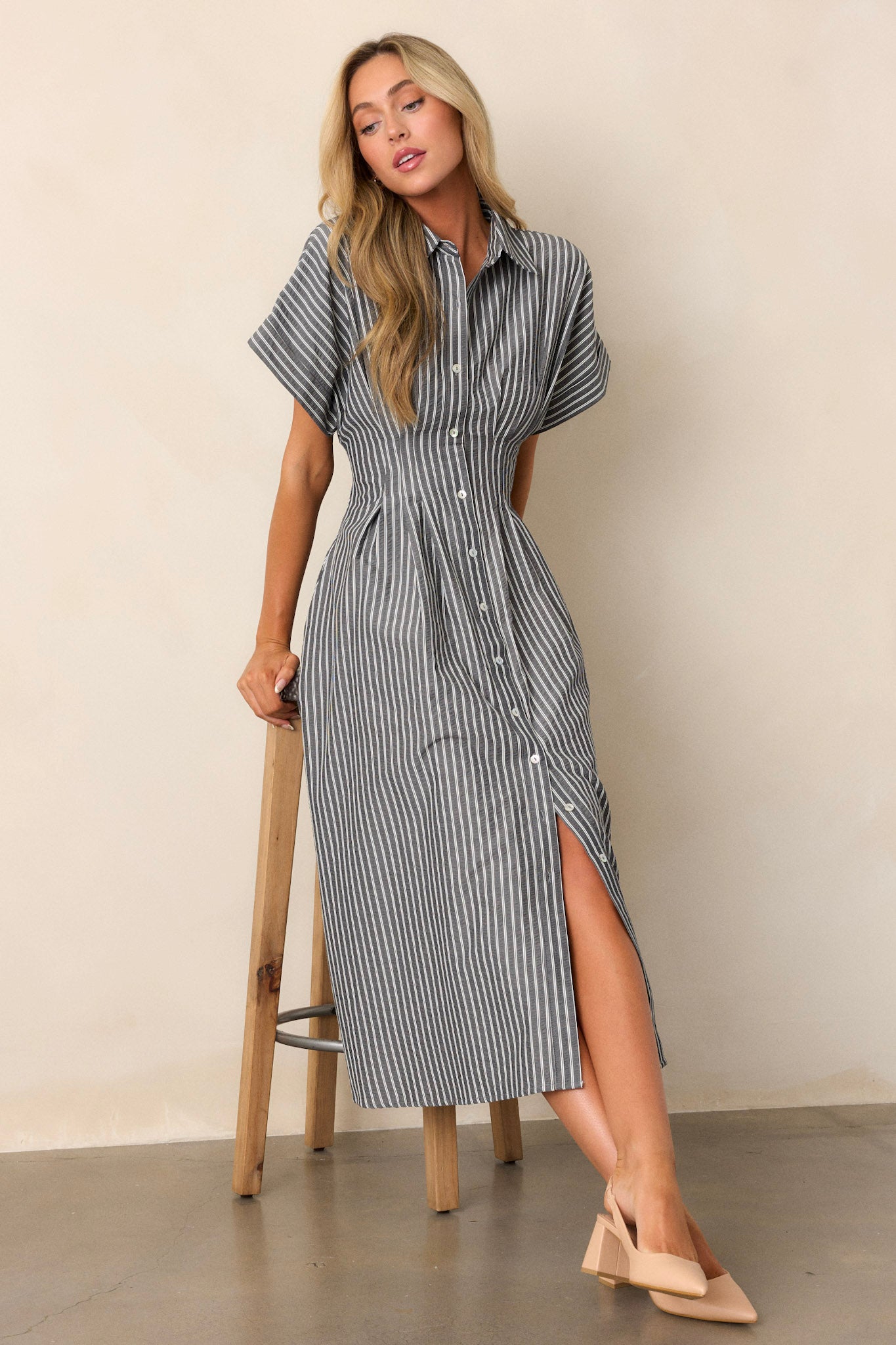 Black dress with a collar neckline, button-front detailing, and short sleeves, featuring a subtle stripe pattern across the top.