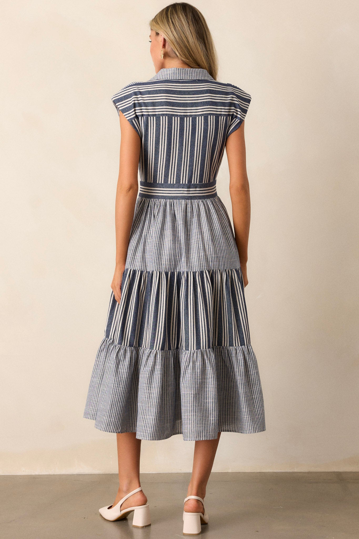 Back view of the navy dress, showing the continuation of the mixed stripe pattern across the back and the structured fit at the shoulders.