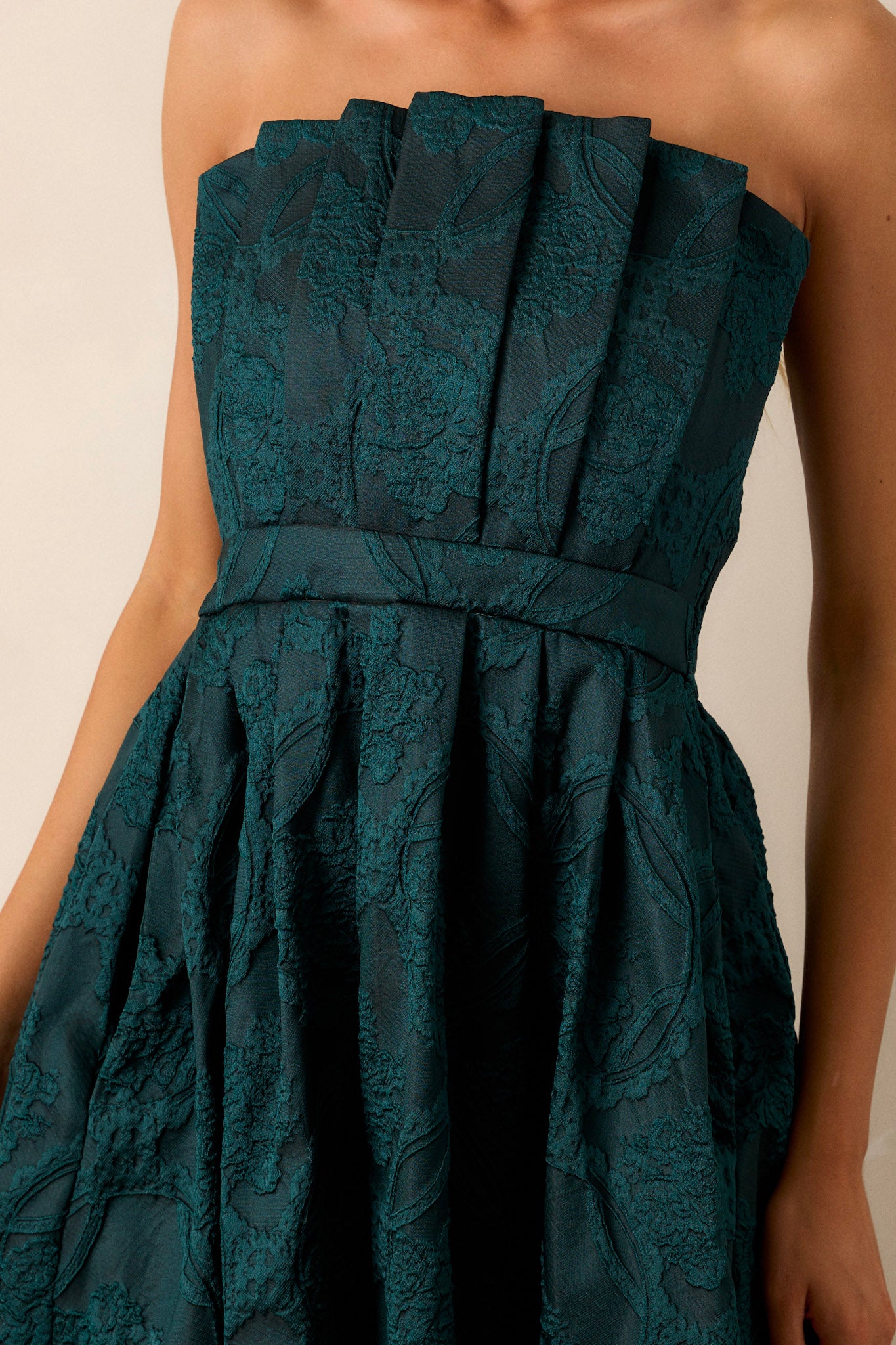 Close-up of the smocked back and the discrete zipper on the green dress, showing the texture and fit of the back.