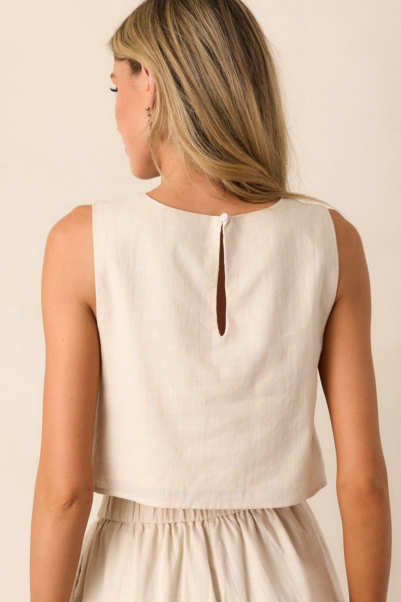 A back view of the crop top, showcasing the simple yet stylish design, emphasizing the keyhole closure and the overall clean lines of the garment.