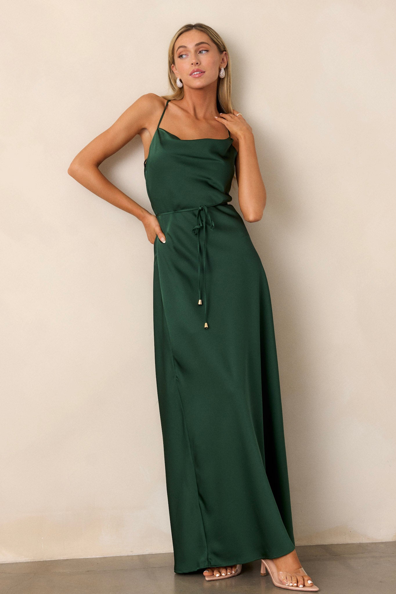 Emerald dress featuring a draped cowl neckline and adjustable straps, with a smooth satin finish across the top.