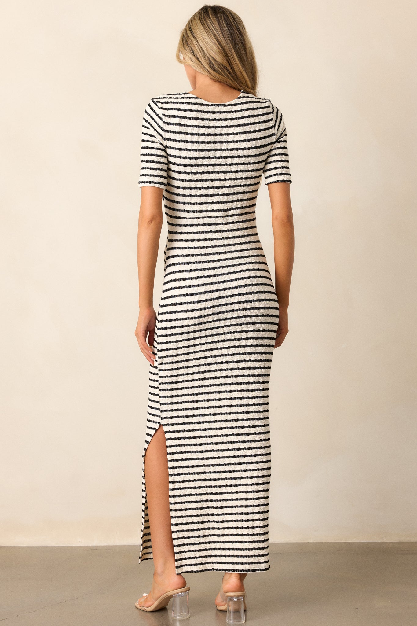 Rear view of the black stripe maxi dress, showcasing the short sleeves and the continuation of the stripe pattern along the back.