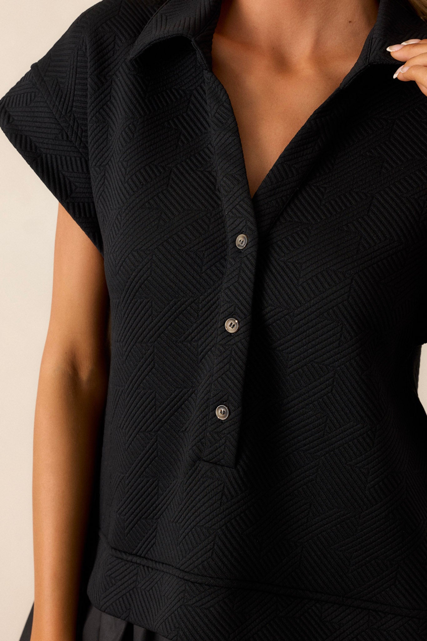 Close-up of the black quilted dress showing the collared v-neckline, functional button front, and quilted bodice.