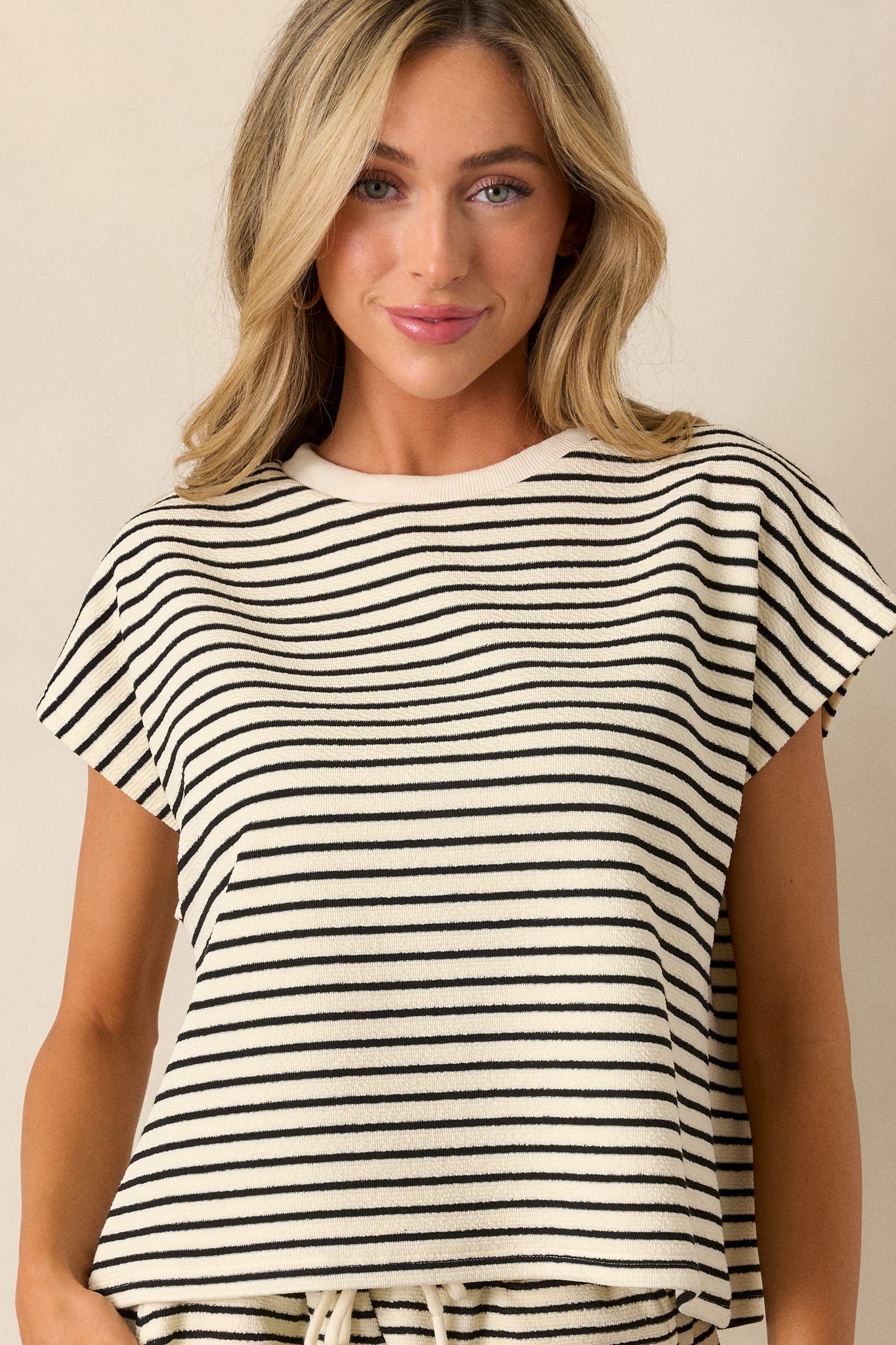  This ivory top features cap sleeves, a ribbed neckline, and a boxy fit.