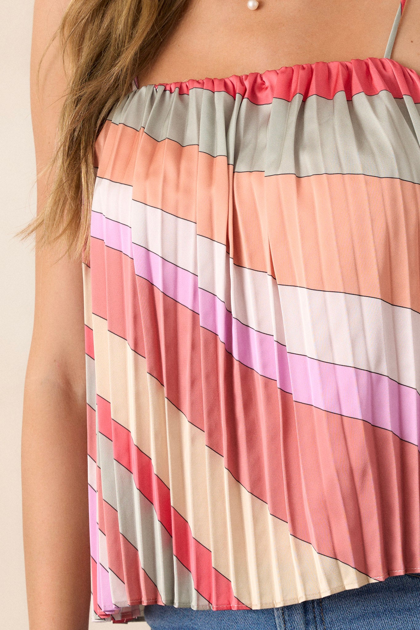 Close-up of the pink coral top showing the square neck, pleated design, and thin adjustable straps.